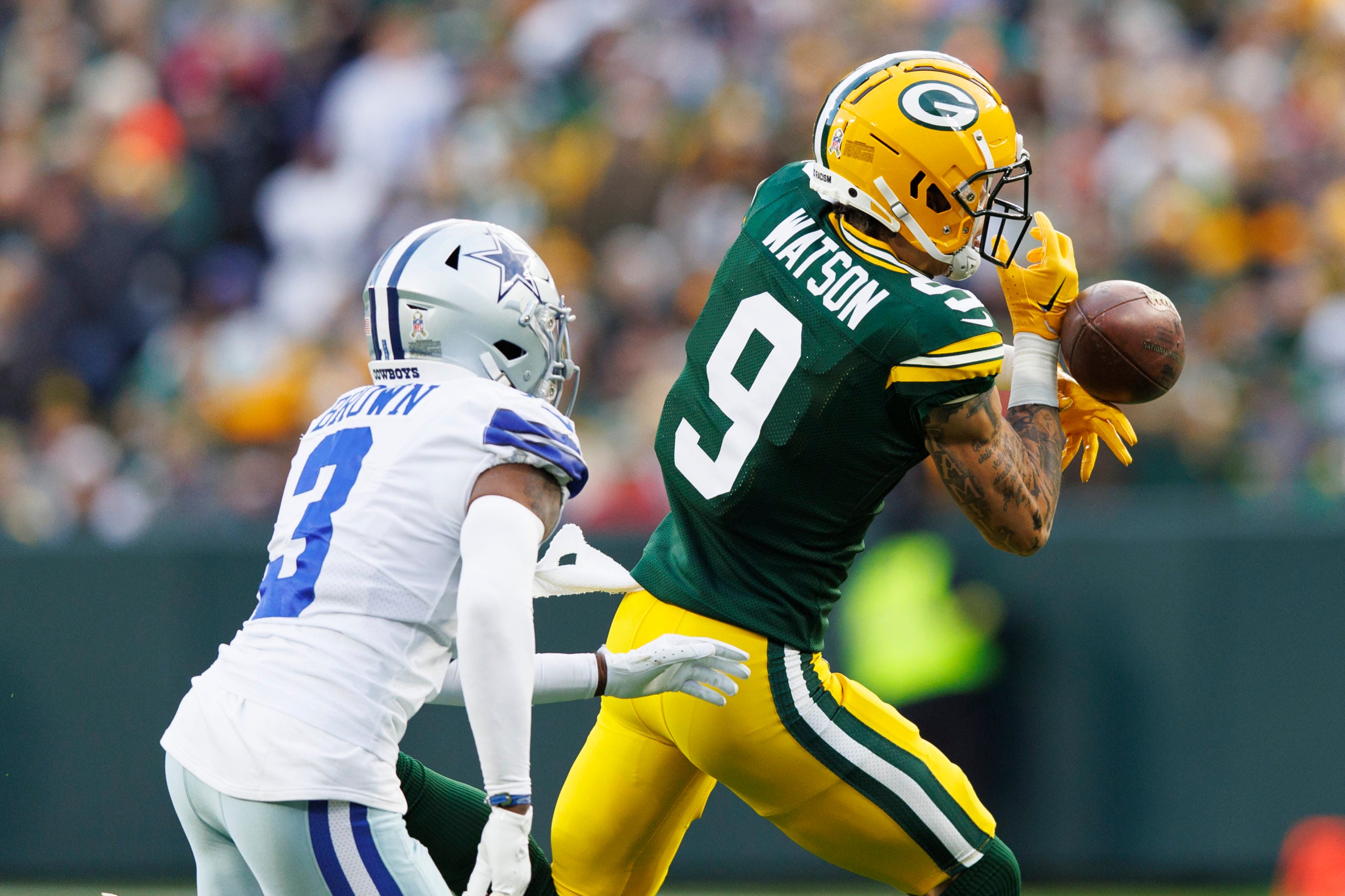 Nov 13, 2022; Green Bay, Wisconsin, USA;  Green Bay Packers wide receiver Christian Watson (9) drops a pass in front of Dallas Cowboys cornerback Anthony Brown (3) during the first quarter at Lambeau Field. Mandatory Credit: Jeff Hanisch-USA TODAY Sports