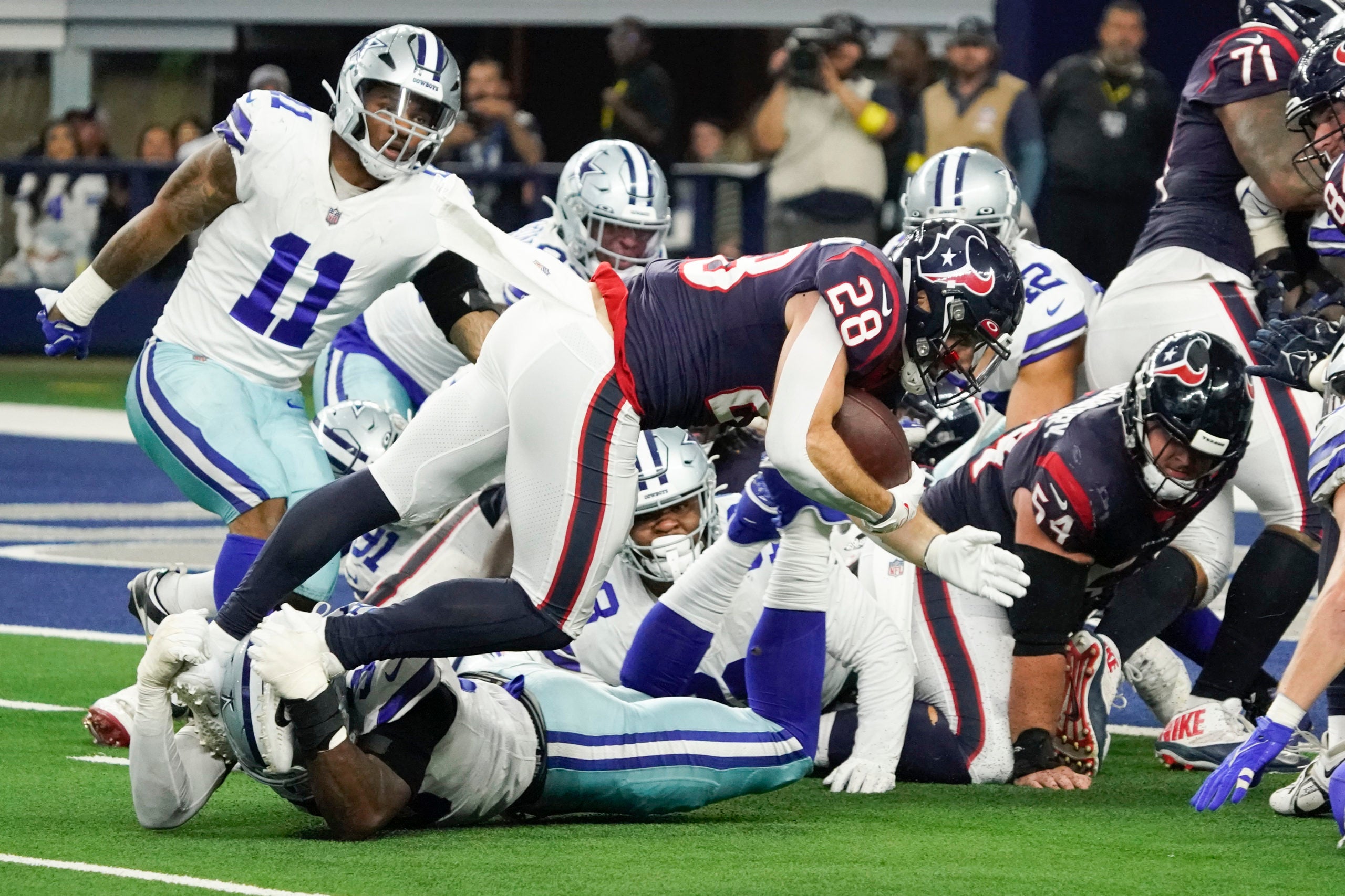 Dec 11, 2022; Arlington, Texas, USA; Houston Texans running back Rex Burkhead (28) is tackled short of the goal line by Dallas Cowboys defensive end DeMarcus Lawrence (90) during the second half at AT&T Stadium. Mandatory Credit: Raymond Carlin III-USA TODAY Sports
