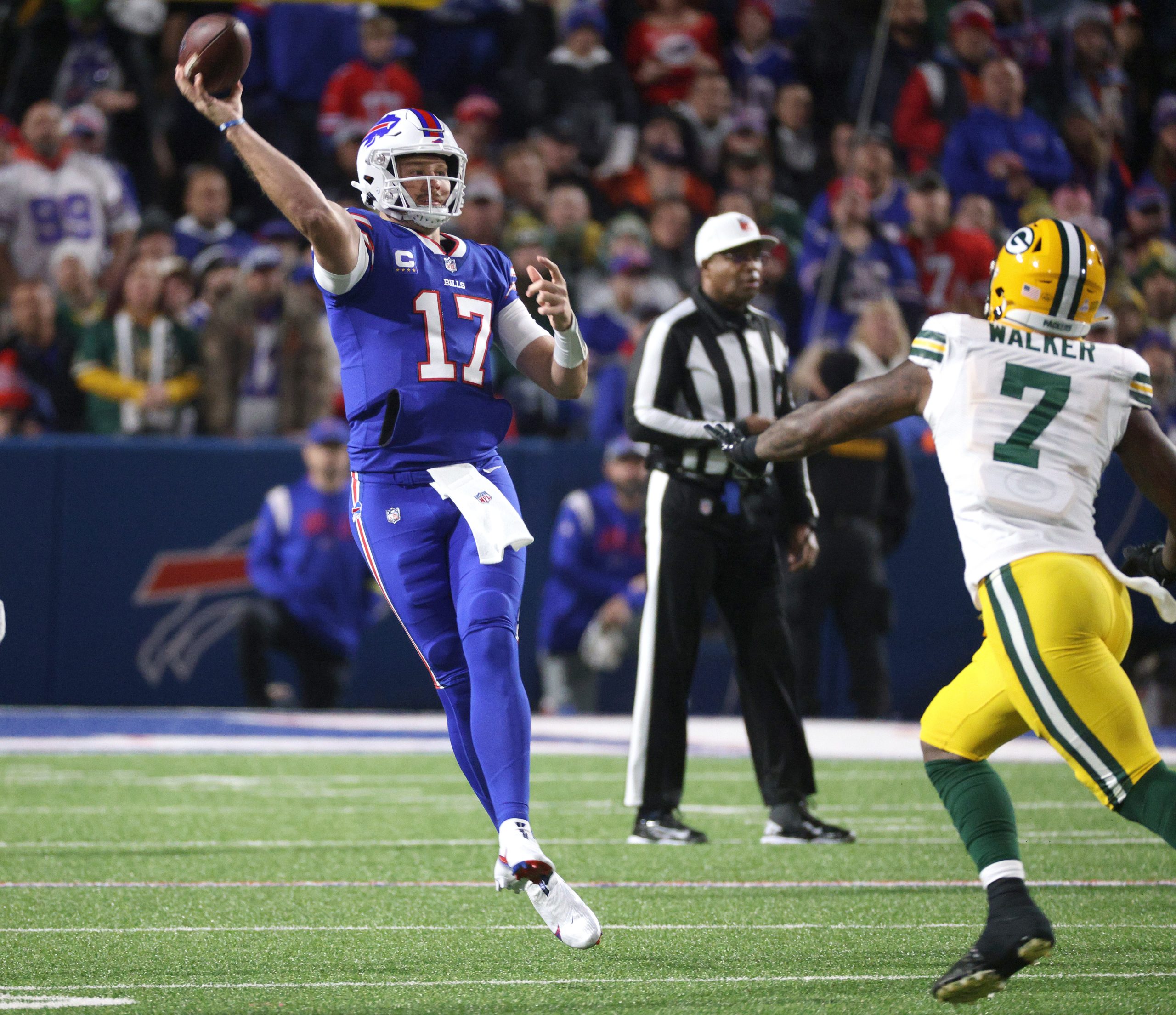 Bills quarterback Josh Allen makes an off balance throw as he is pressured by Packers linebacker Quay Walker.