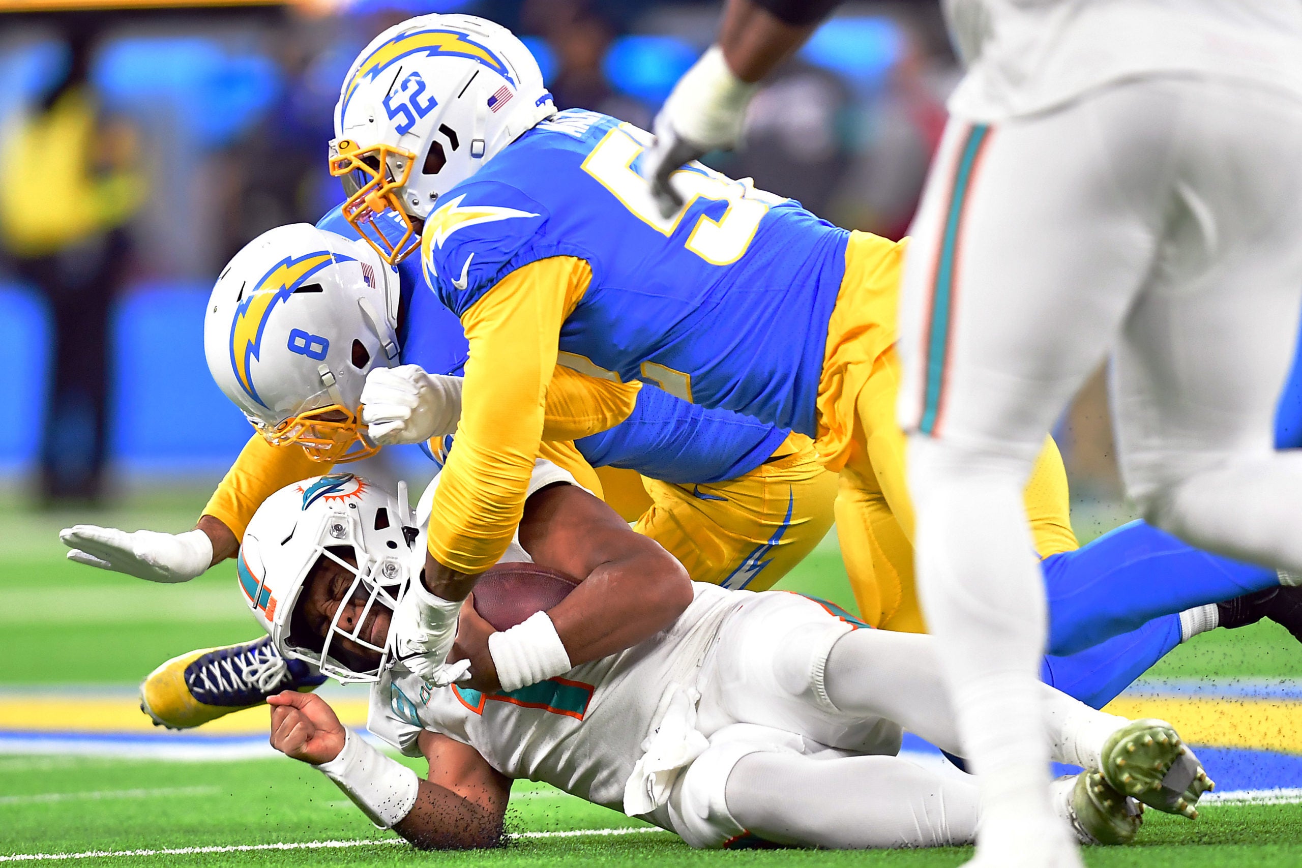 Dec 11, 2022; Inglewood, California, USA; Miami Dolphins quarterback Tua Tagovailoa (1) is brought down by Los Angeles Chargers linebacker Kyle Van Noy (8) and linebacker Khalil Mack (52) during the second half at SoFi Stadium. Mandatory Credit: Gary A. Vasquez-USA TODAY Sports