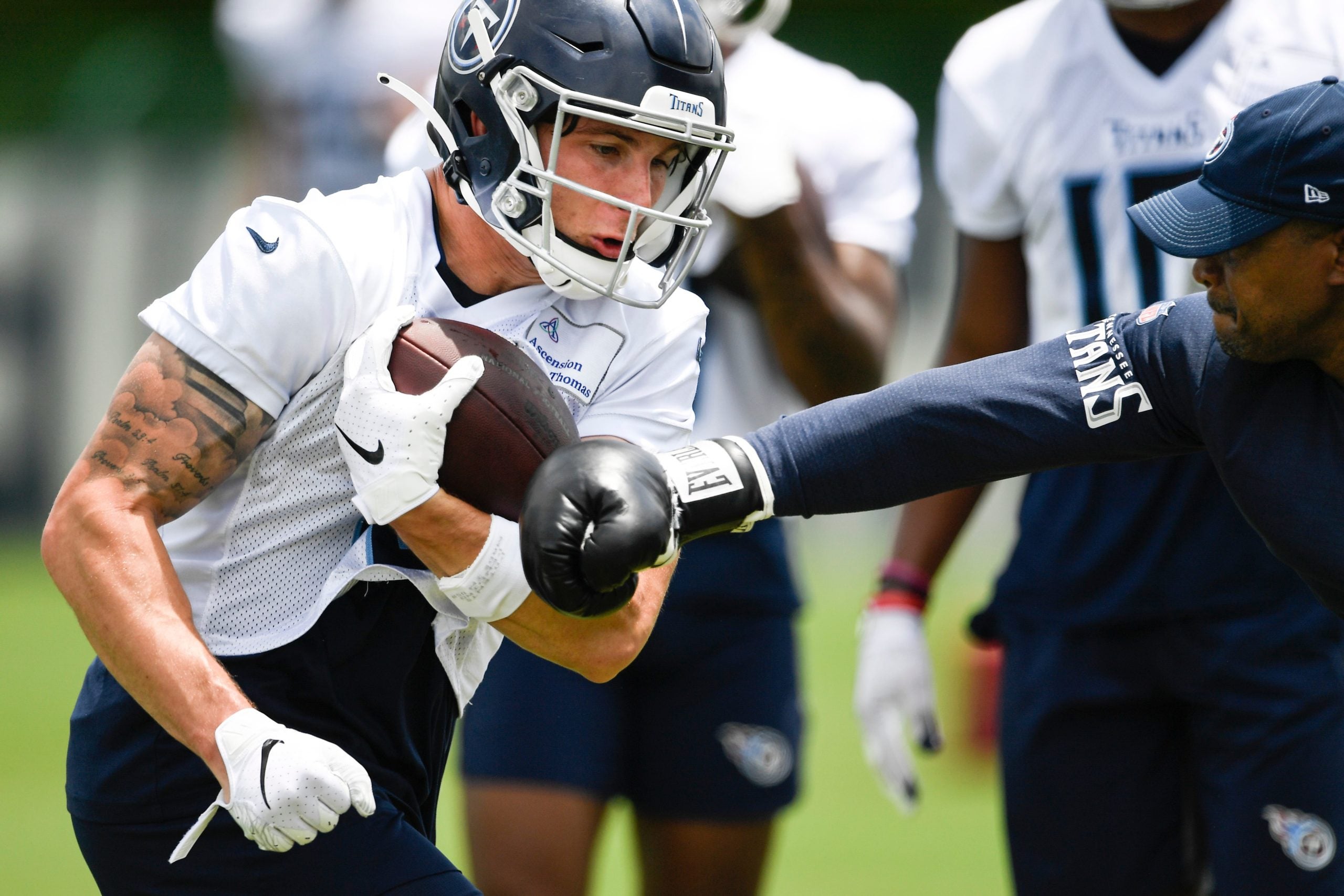Titans wide receiver Mason Kinsey (12) holds onto the ball as wide receivers coach Rob Moore tries to punch it out during practice at Saint Thomas Sports Park Thursday, May 27, 2021 in Nashville, Tenn. Nas Titans Otas 023