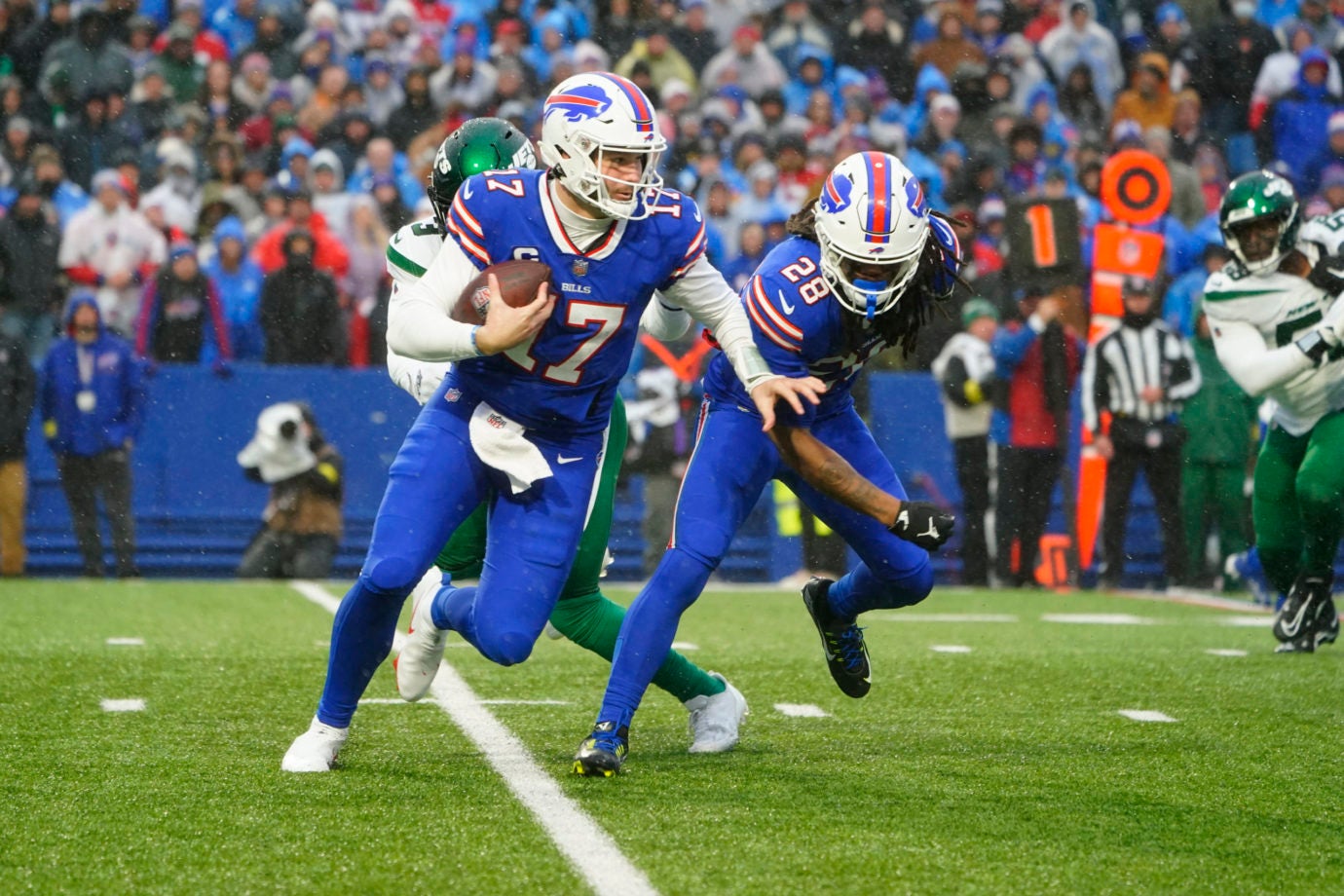 Dec 11, 2022; Orchard Park, New York, USA; Buffalo Bills quarterback Josh Allen (17) runs with the ball with Buffalo Bills running back James Cook (28) during the first half against the New York Jets at Highmark Stadium. Mandatory Credit: Gregory Fisher-USA TODAY Sports