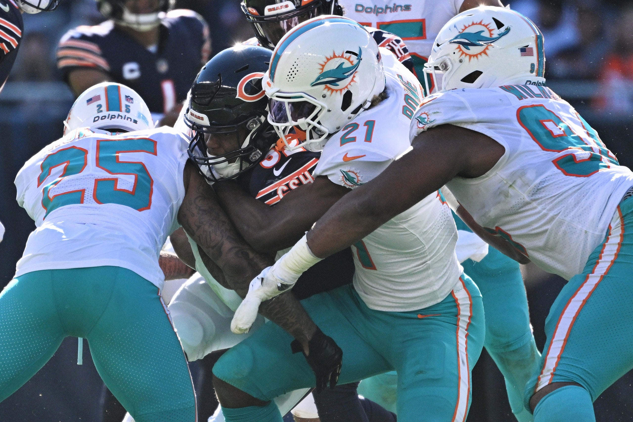 Nov 6, 2022; Chicago, Illinois, USA;  Miami Dolphins cornerback Xavien Howard (25), safety Eric Rowe (21) and defensive tackle Christian Wilkins (94) gang up to tackle Chicago Bears running back David Montgomery (32) in the second quarter at Soldier Field. Mandatory Credit: Jamie Sabau-USA TODAY Sports