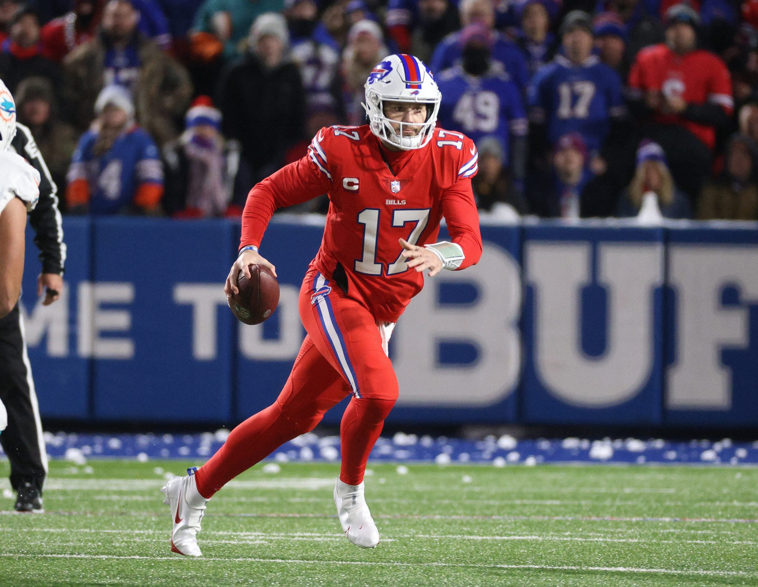 Bills quarterback Josh Allen rolls to his left as he looks downfield.