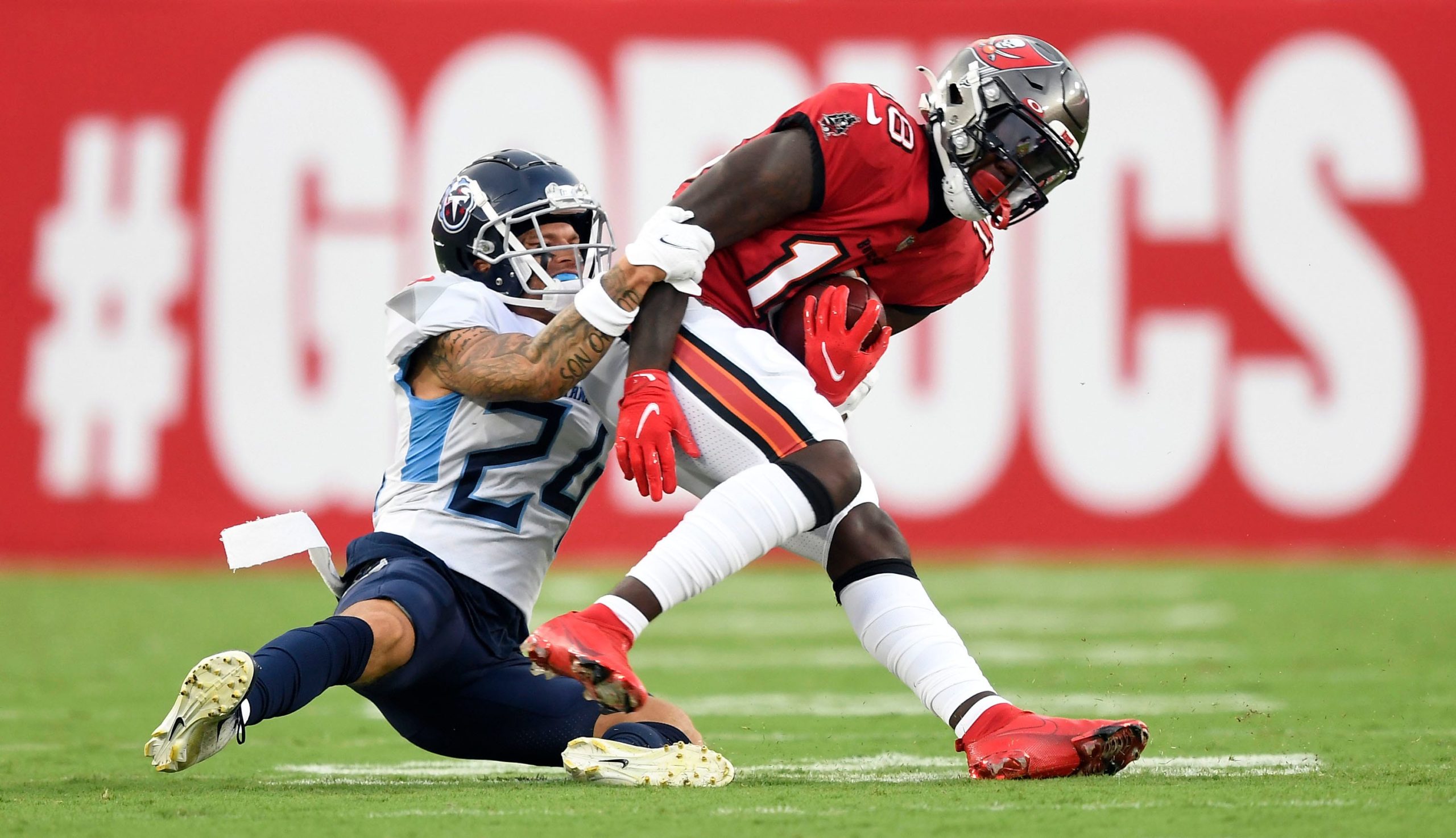 Tennessee Titans cornerback Elijah Molden (24) tackles Tampa Bay Buccaneers wide receiver Tyler Johnson (18) during the first quarter of an NFL preseason game at Raymond James Stadium Saturday, Aug. 21, 2021 in Tampa, Fla. Titans Bucs 034