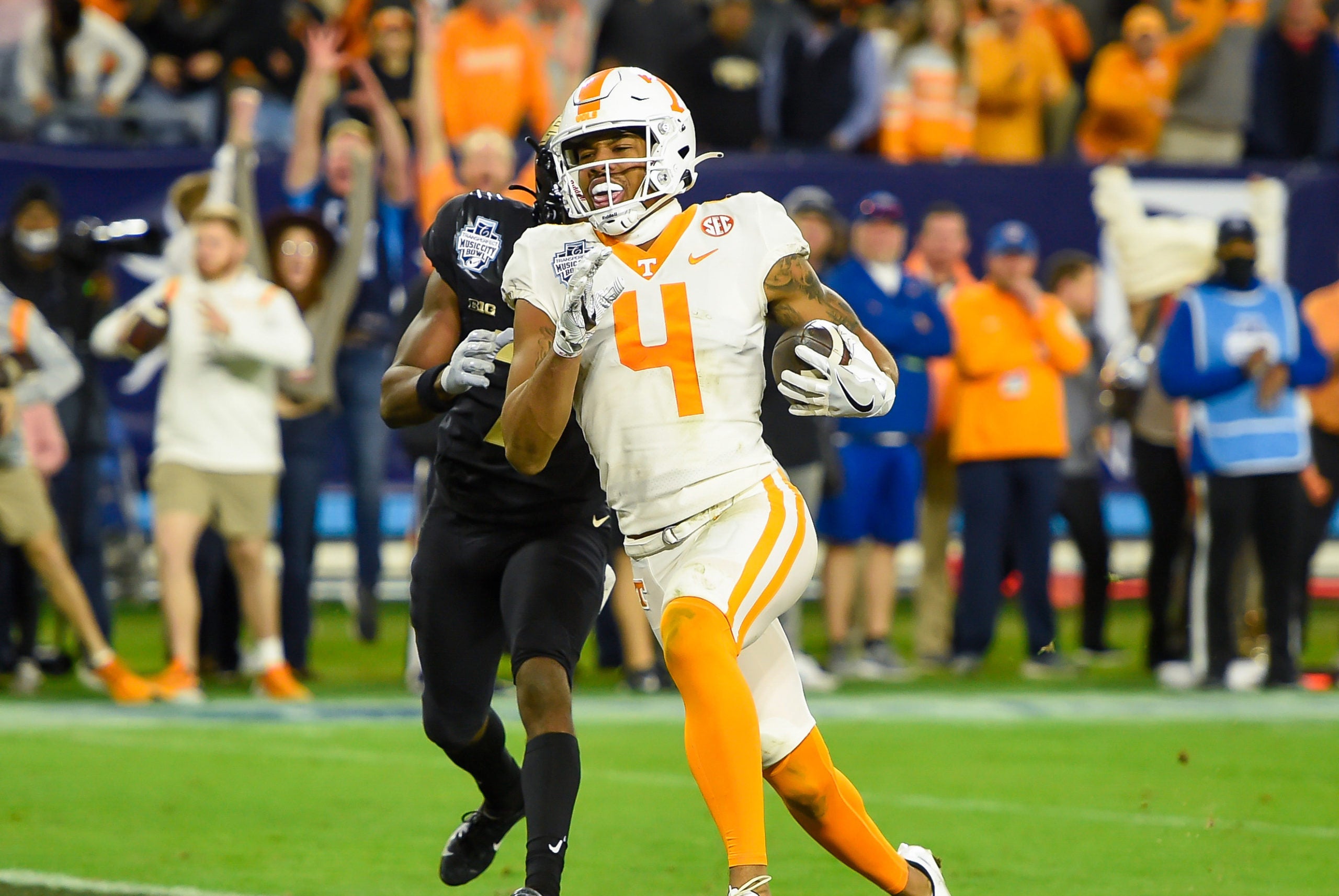 Dec 30, 2021; Nashville, TN, USA;  Tennessee Volunteers wide receiver Cedric Tillman (4) scores a touchdown past Purdue Boilermakers cornerback Jamari Brown (7) during the second half at Nissan Stadium. Mandatory Credit: Steve Roberts-USA TODAY Sports