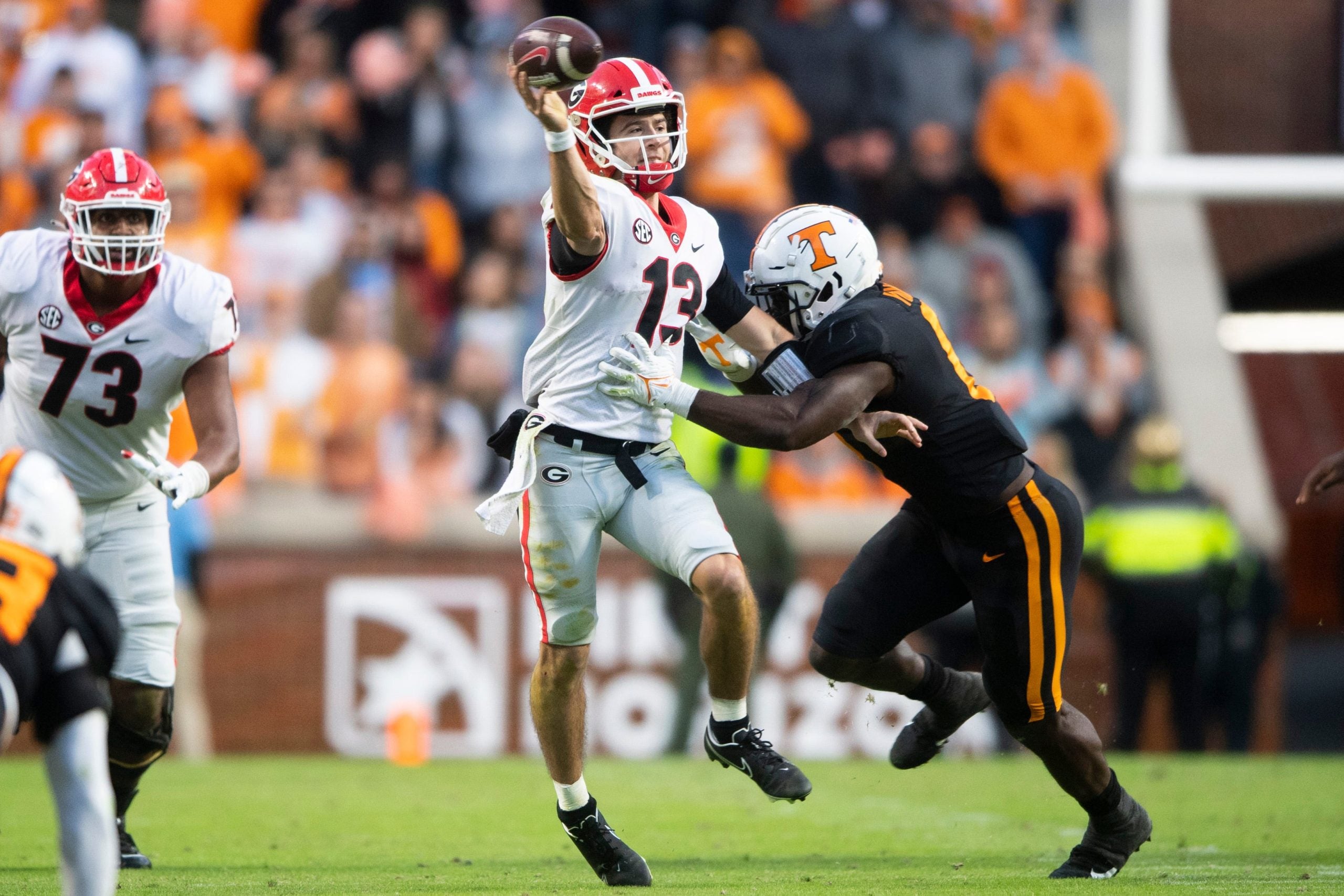 Georgia quarterback Stetson Bennett (13) throws under pressure by Tennessee defensive lineman/linebacker Byron Young (6) during a football game against the Georgia Bulldogs at Neyland Stadium in Knoxville, Tenn. on Saturday, Nov. 13, 2021. Kns Tennessee Georgia Football Bp