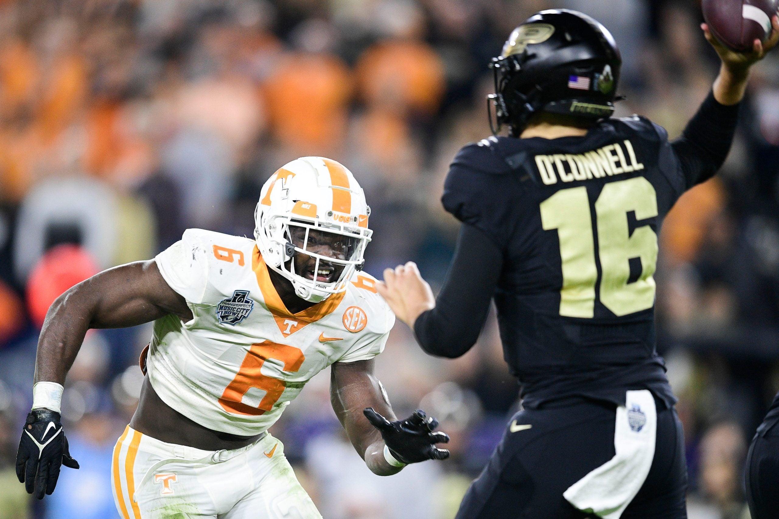Tennessee defensive lineman/linebacker Byron Young (6) defends against Purdue quarterback Aidan O'Connell (16) at the 2021 Music City Bowl NCAA college football game at Nissan Stadium in Nashville, Tenn. on Thursday, Dec. 30, 2021. Kns Tennessee Purdue