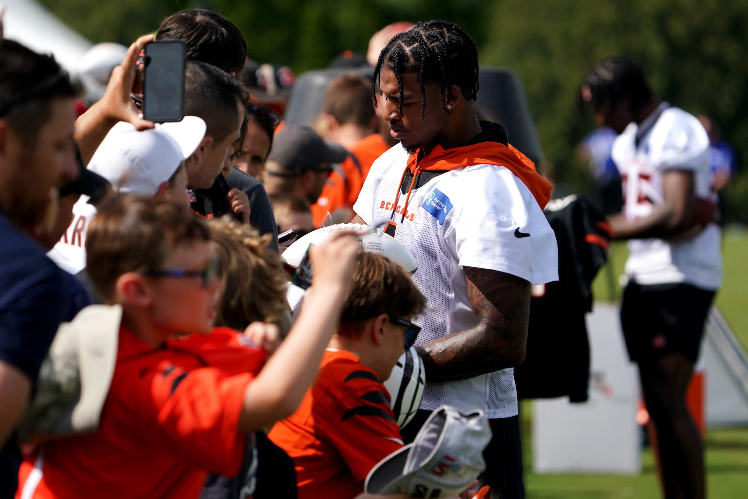 Cincinnati Bengals wide receiver Ja'Marr Chase (1), center, and Cincinnati Bengals wide receiver Tee Higgins (85), right, sign autographs at the conclusion of Cincinnati Bengals training camp practice, Friday, July 29, 2022, at the practice fields next to Paul Brown Stadium in Cincinnati. Cincinnati Bengals Training Camp July 29 0035