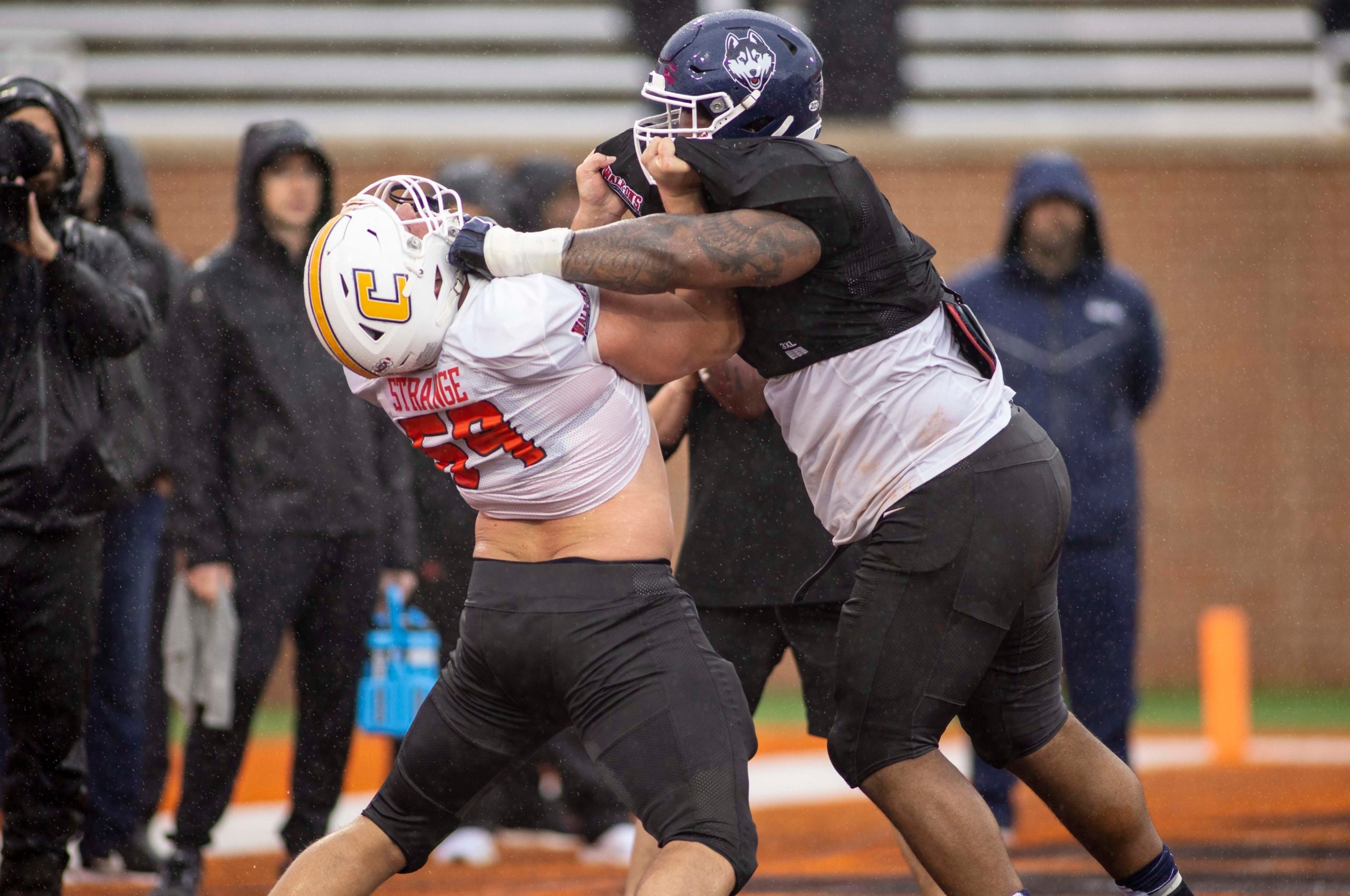 Feb 2, 2022; Mobile, AL, USA;  National offensive lineman Cole Strange of Tennessee-Chattanooga (69) spars with National defensive lineman Travis Jones of Connecticut (57) during National practice for the 2022 Senior Bowl in Mobile, AL, USA. Mandatory Credit: Vasha Hunt-USA TODAY Sports