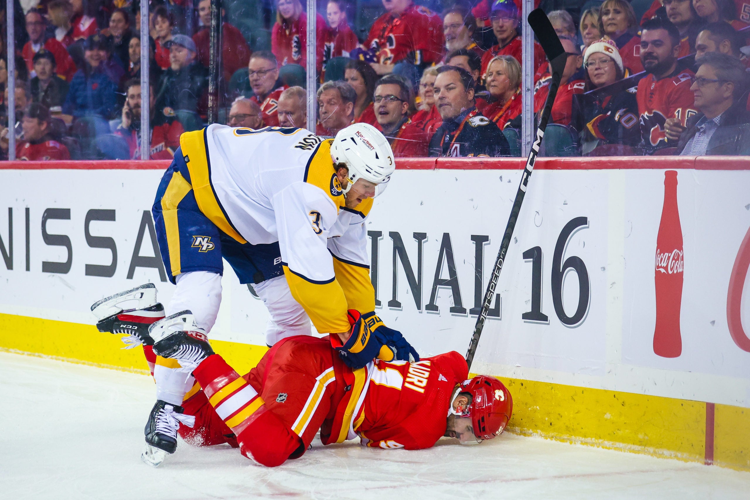 Nashville Predators Jeremy Lauzon holds Calgary's Nazem Kadri down after finishing a check