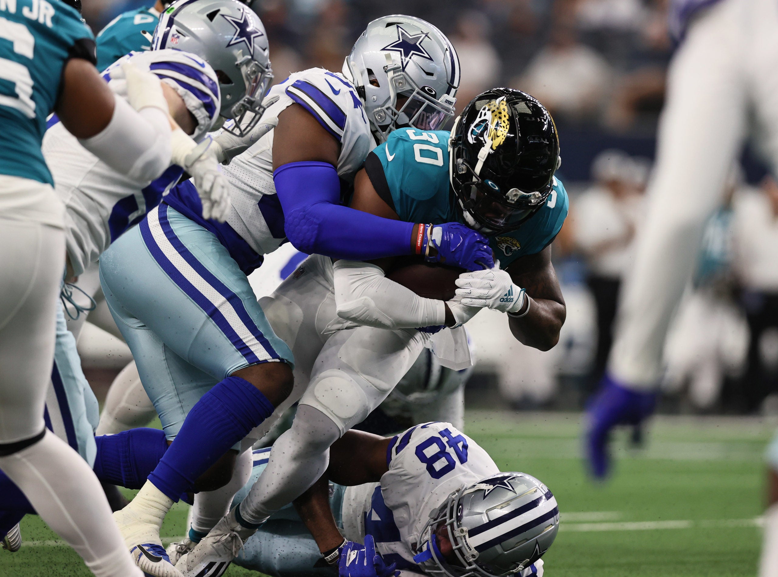 Aug 29, 2021; Arlington, Texas, USA; Jacksonville Jaguars running back James Robinson (30) runs with the ball against Dallas Cowboys defensive end Ron'Dell Carter (97) in the first quarter at AT&T Stadium. Mandatory Credit: Matthew Emmons-USA TODAY Sports