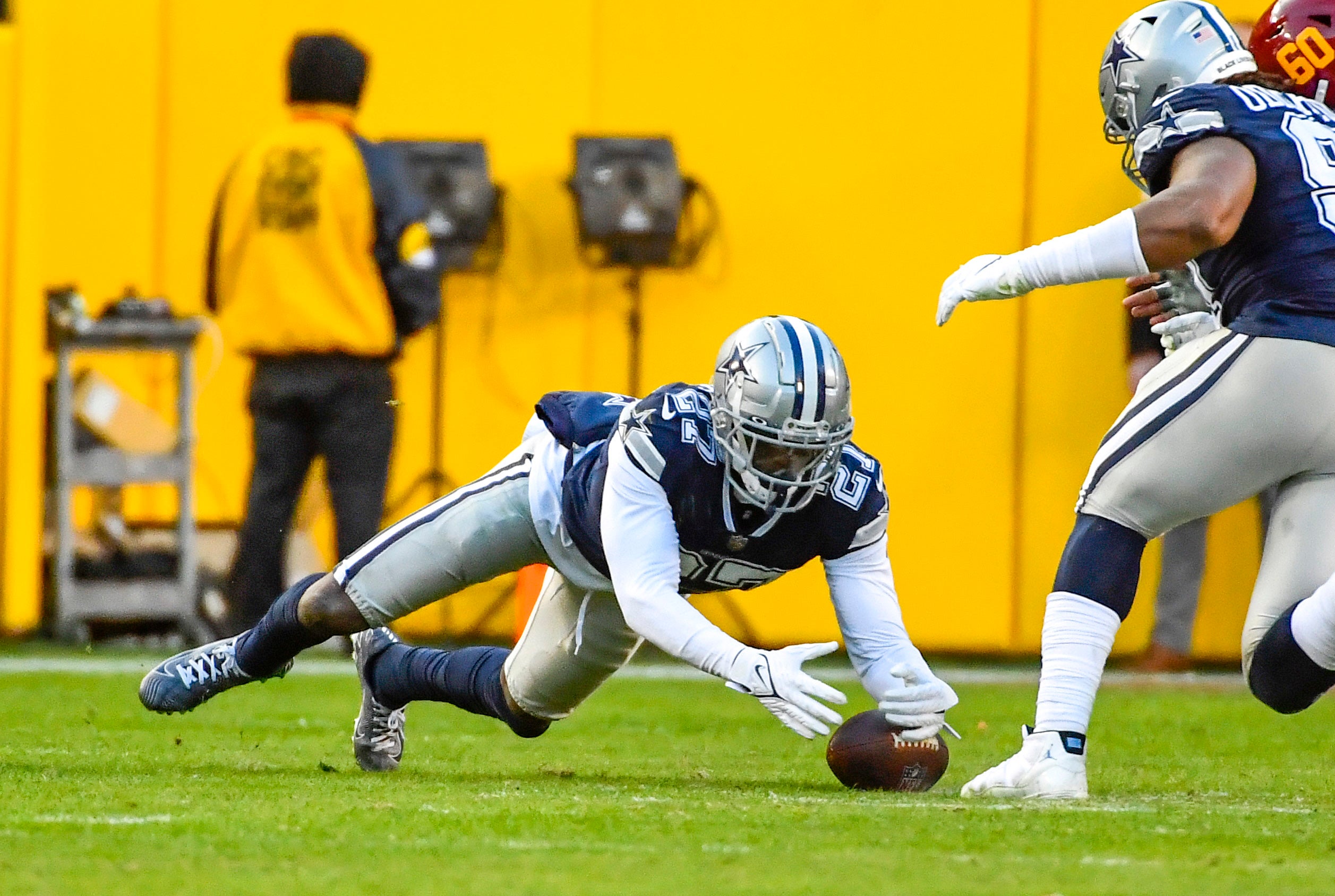 Dec 12, 2021; Landover, Maryland, USA; Dallas Cowboys safety Jayron Kearse (27) recovers a fumble against the Washington Football Team during the second half at FedExField. Mandatory Credit: Brad Mills-USA TODAY Sports