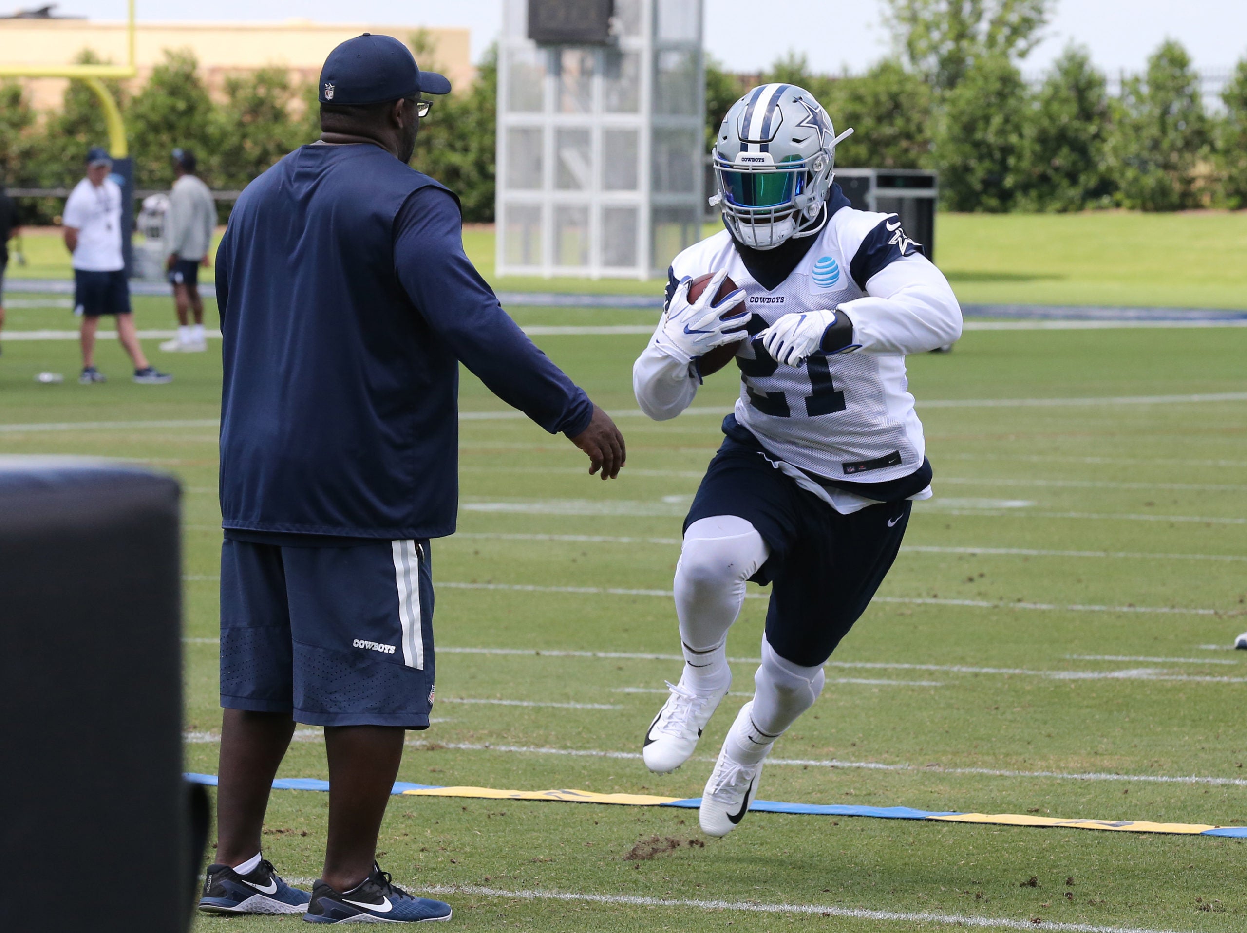 May 23, 2018; Frisco, TX, USA; Dallas Cowboys running back Ezekiel Elliott (21) runs with through drills with runing backs coach Gary Brown during organized team activities at Dallas Cowboys headquarters at The Star. Mandatory Credit: Matthew Emmons-USA TODAY Sports