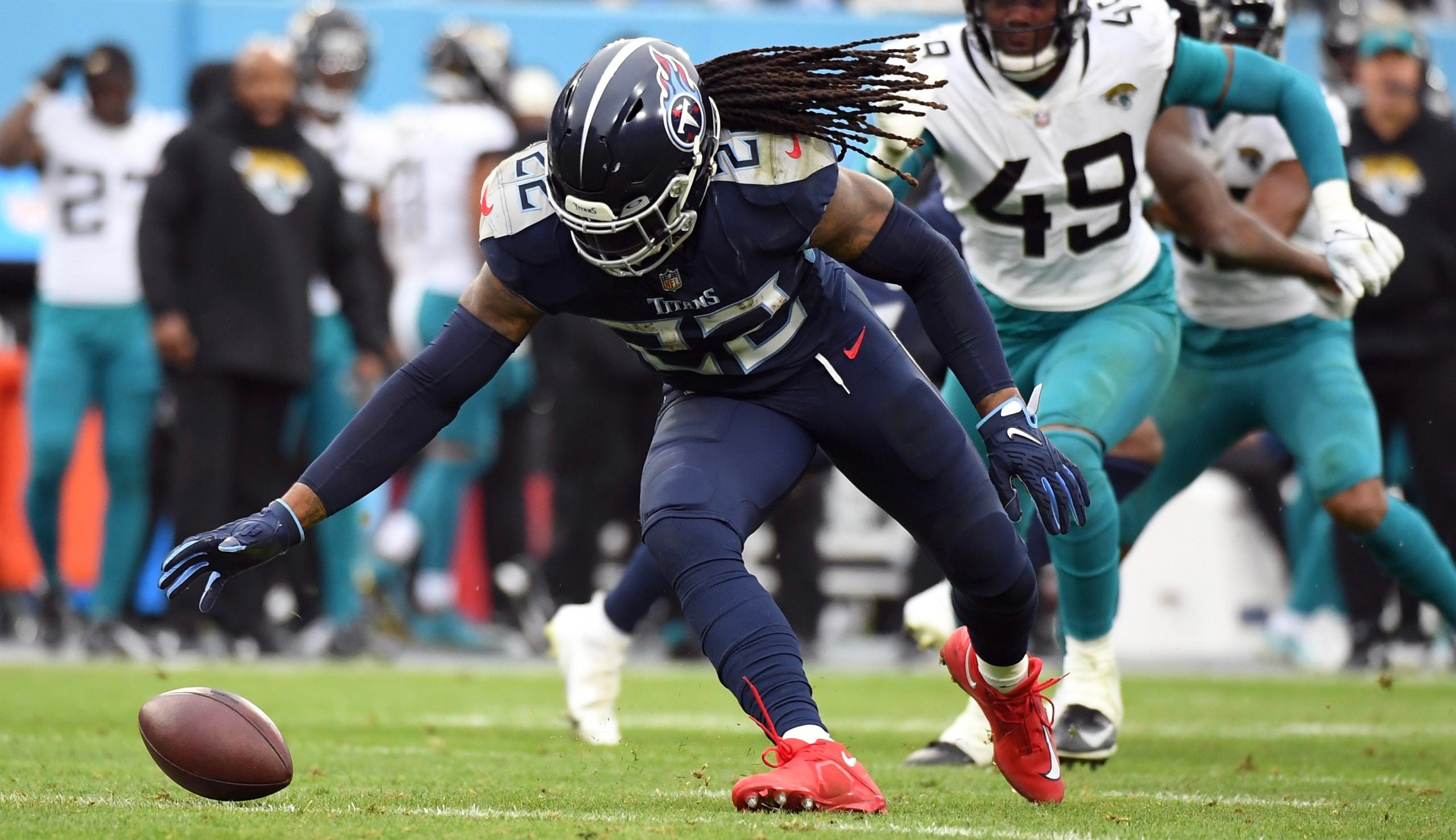 Dec 11, 2022; Nashville, Tennessee, USA; Tennessee Titans running back Derrick Henry (22) fumbles the snap that was later recovered by Jacksonville Jaguars defensive end Arden Key (49) during the second half at Nissan Stadium. Mandatory Credit: Christopher Hanewinckel-USA TODAY Sports
