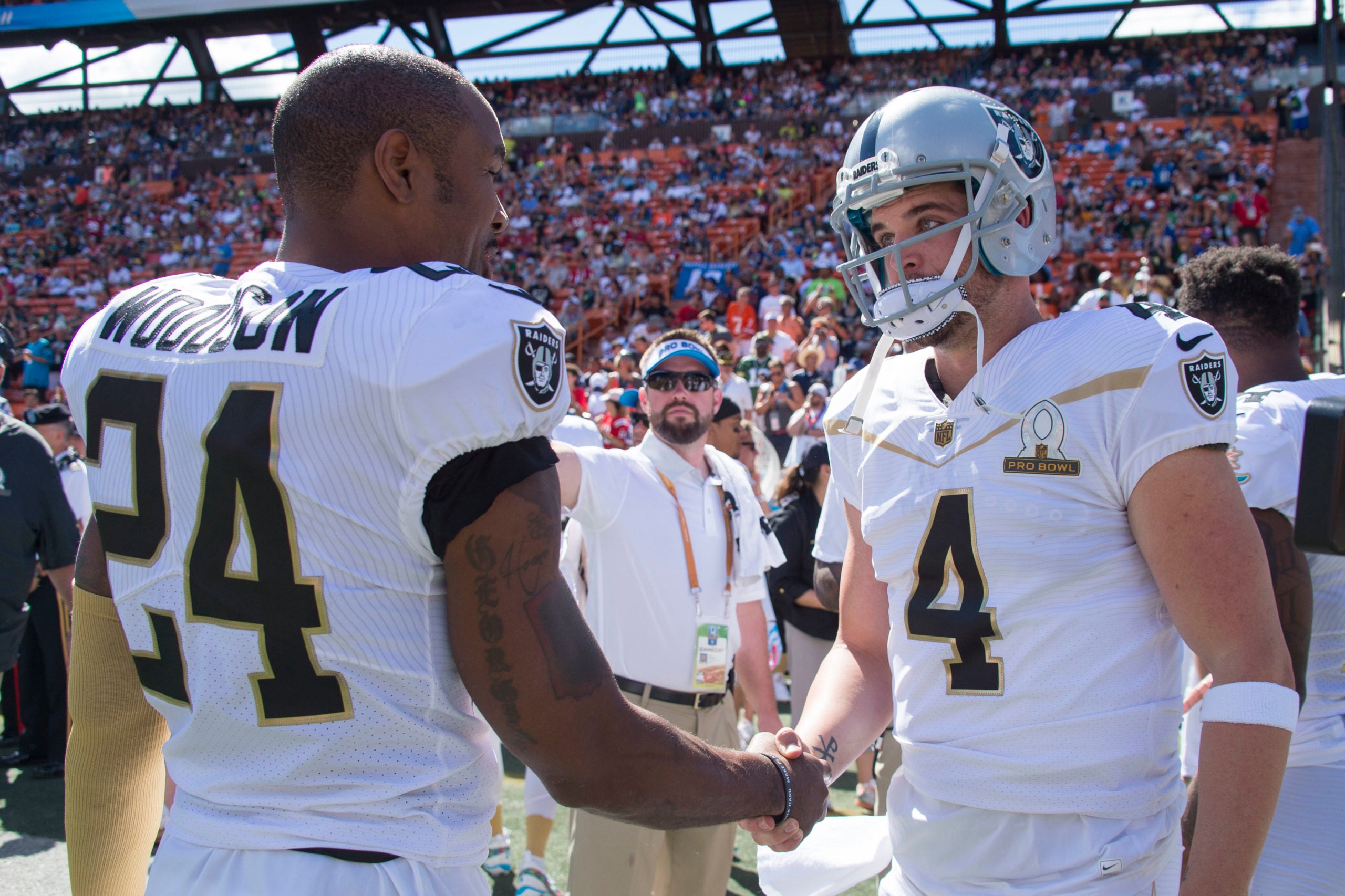Team Rice strong safety Charles Woodson of the Oakland Raiders (24) and quarterback Derek Carr of the Oakland Raiders (4) shake hands before the 2016 Pro Bowl game against Team Irvin at Aloha Stadium.