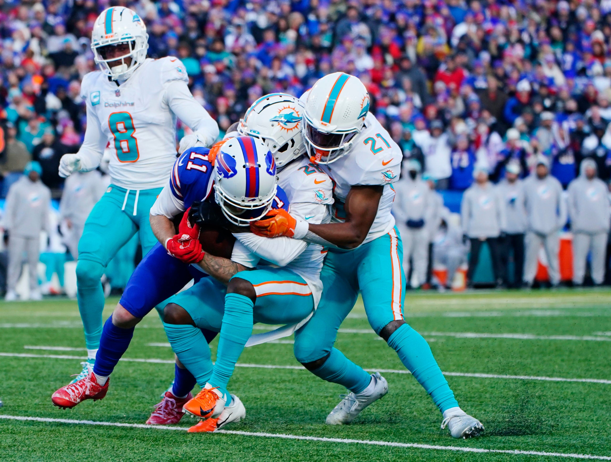 Jan 15, 2023; Orchard Park, NY, USA; Buffalo Bills wide receiver Cole Beasley (11) is tackled by Miami Dolphins safety Eric Rowe (21) and cornerback Kader Kohou (28) during the second half in a NFL wild card game at Highmark Stadium. Mandatory Credit: Gregory Fisher-USA TODAY Sports