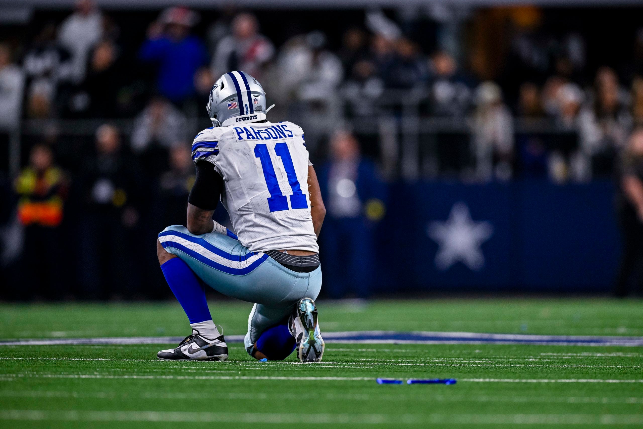 Dec 24, 2022; Arlington, Texas, USA; Dallas Cowboys linebacker Micah Parsons (11) kneels on the field during the second half of the game against the Philadelphia Eagles at AT&T Stadium. Mandatory Credit: Jerome Miron-USA TODAY Sports