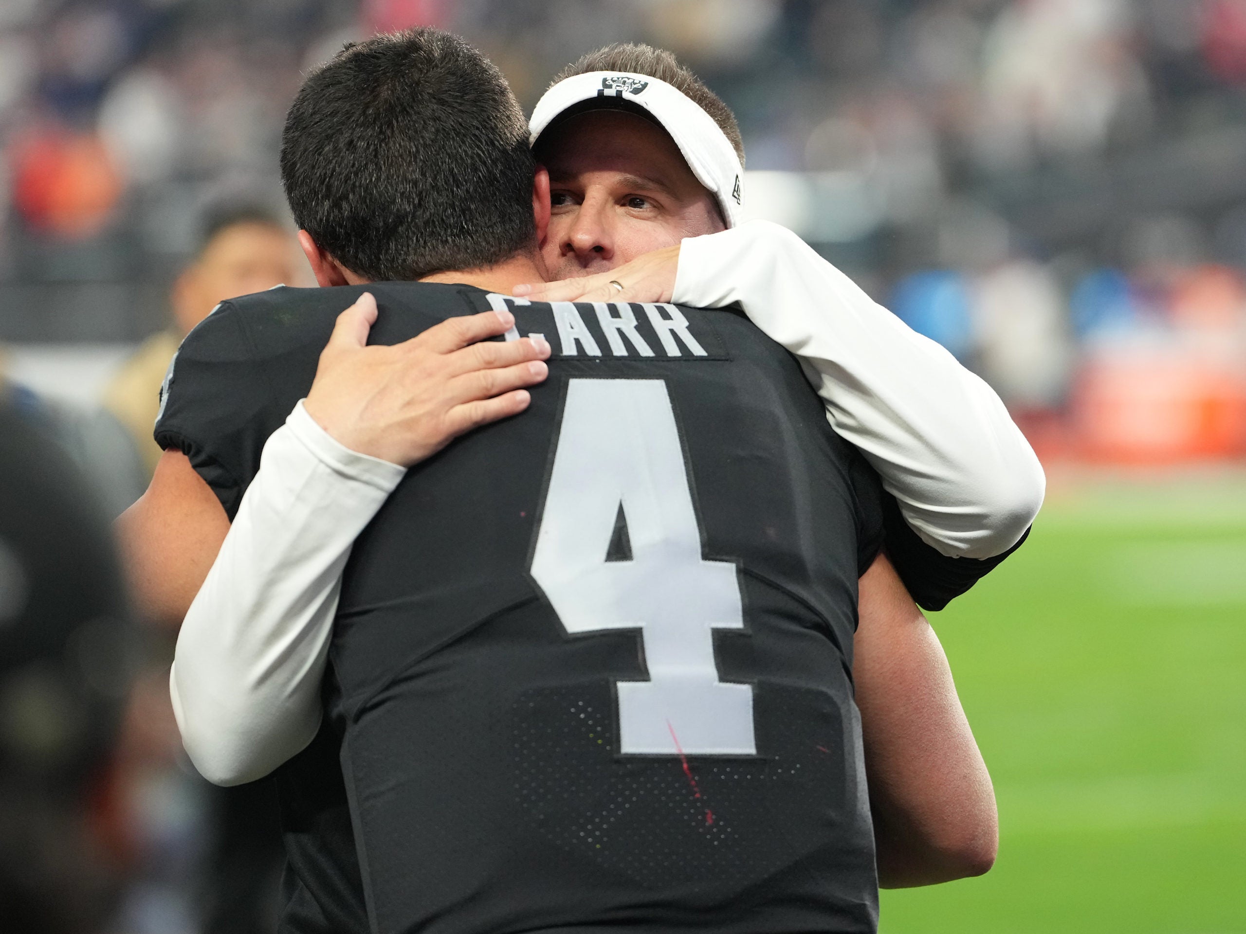 Derek Carr hugs Raiders head coach Josh McDaniels.