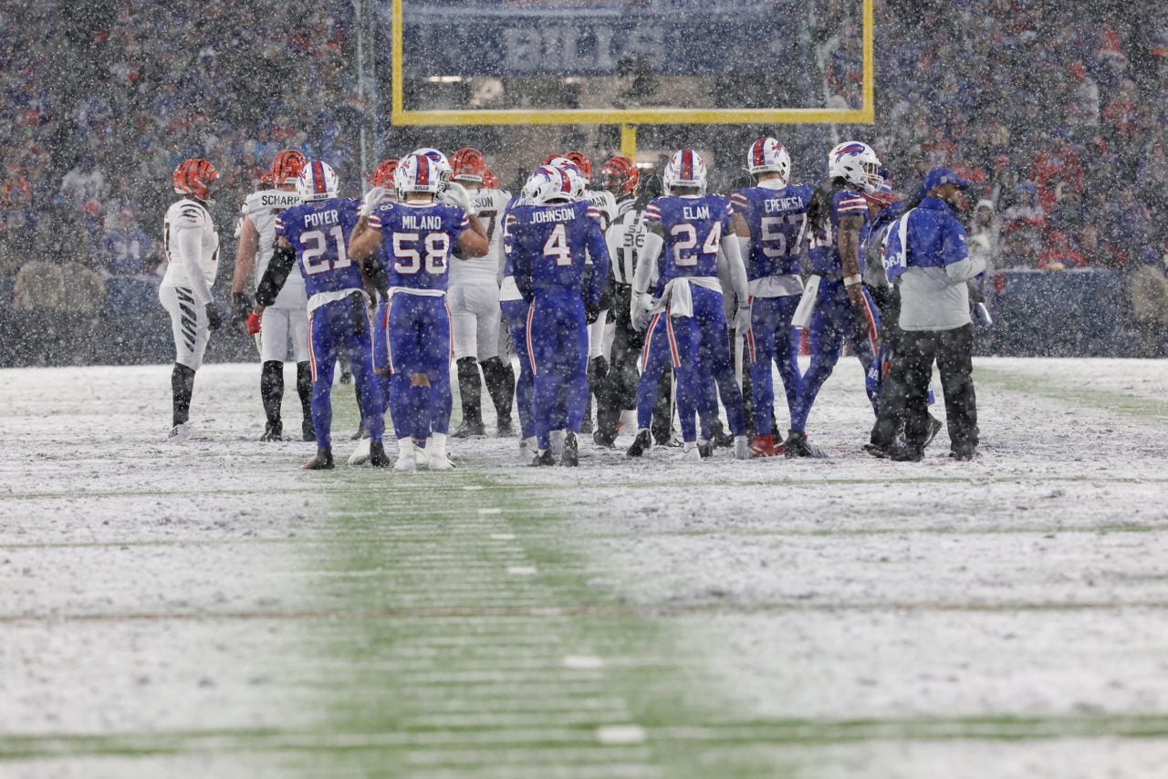 The Bills and the Bengals get water during a time out in the second half of their playoff game in Orchard Park on Jan. 22. Bills Time Out Snowy Field