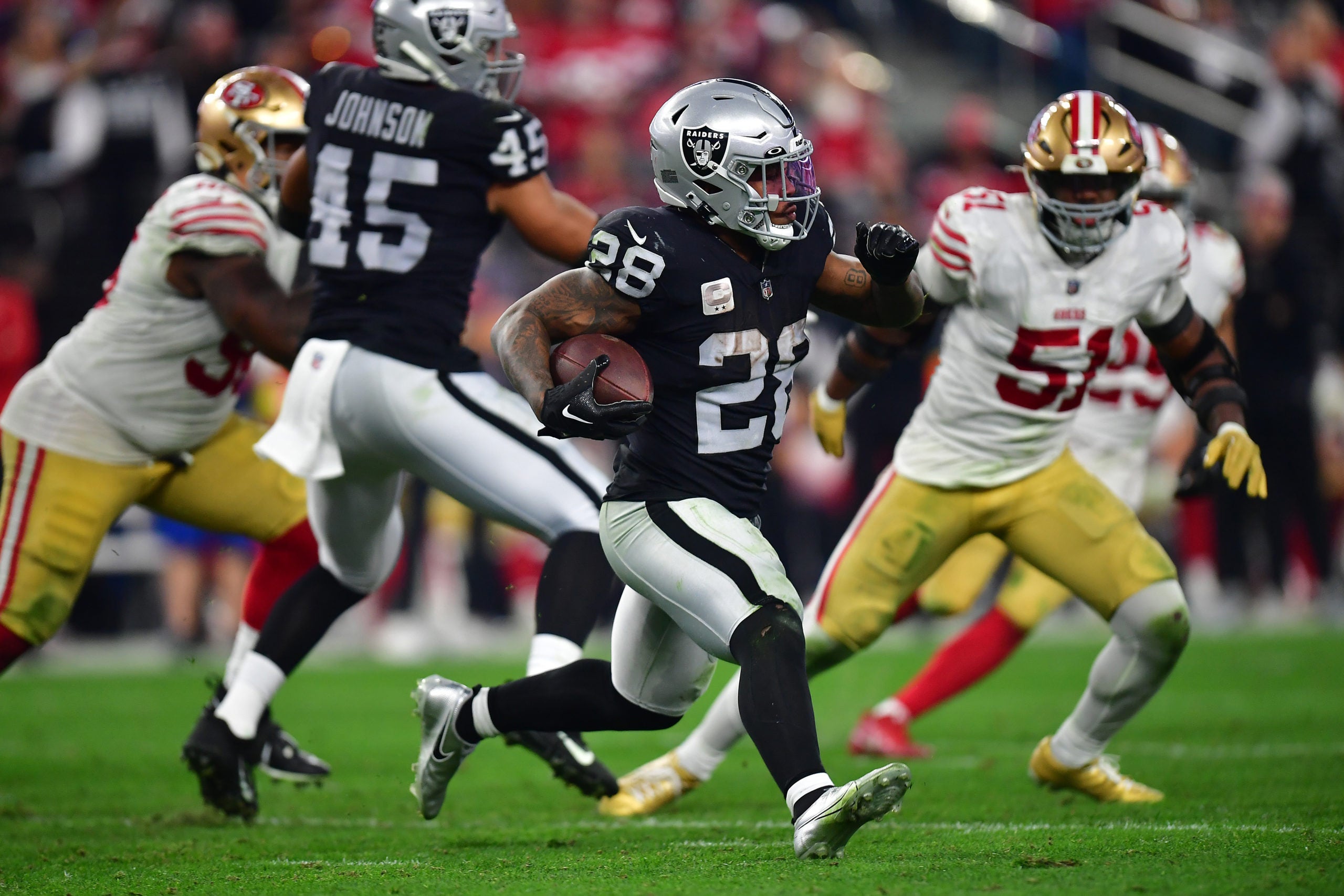 January 1, 2023; Paradise, Nevada, USA; Las Vegas Raiders running back Josh Jacobs (28) runs the ball against the San Francisco 49ers during overtime at Allegiant Stadium. Mandatory Credit: Gary A. Vasquez-USA TODAY Sports