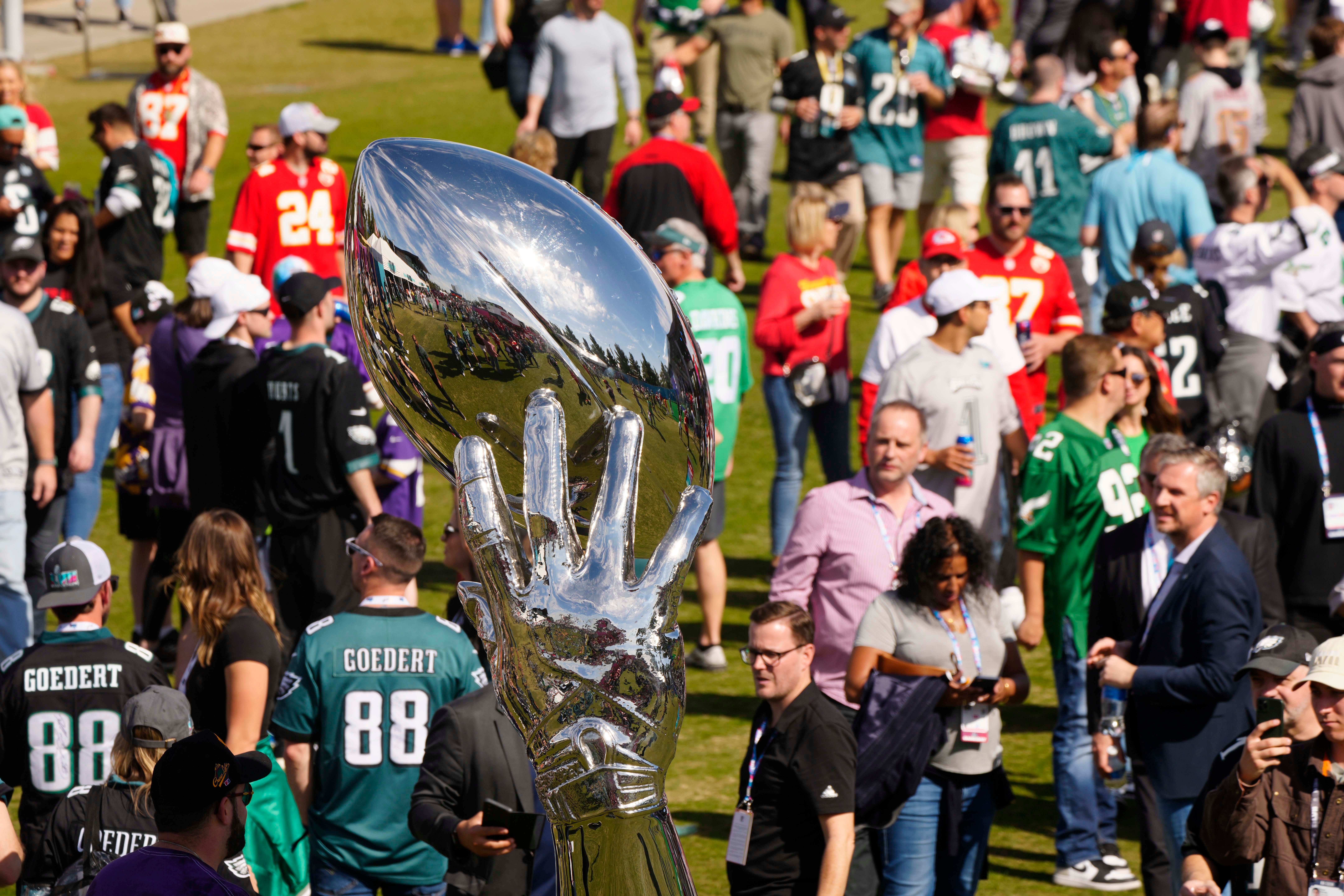 Fans walk past a reflective football sculpture before Super Bowl LVII between the Kansas City Chiefs and Philadelphia Eagles at State Farm Stadium on Feb. 12, 2023, in Glendale, Ariz. Nfl Super Bowl Lvii Kansas City Chiefs Vs Philadelphia Eagles