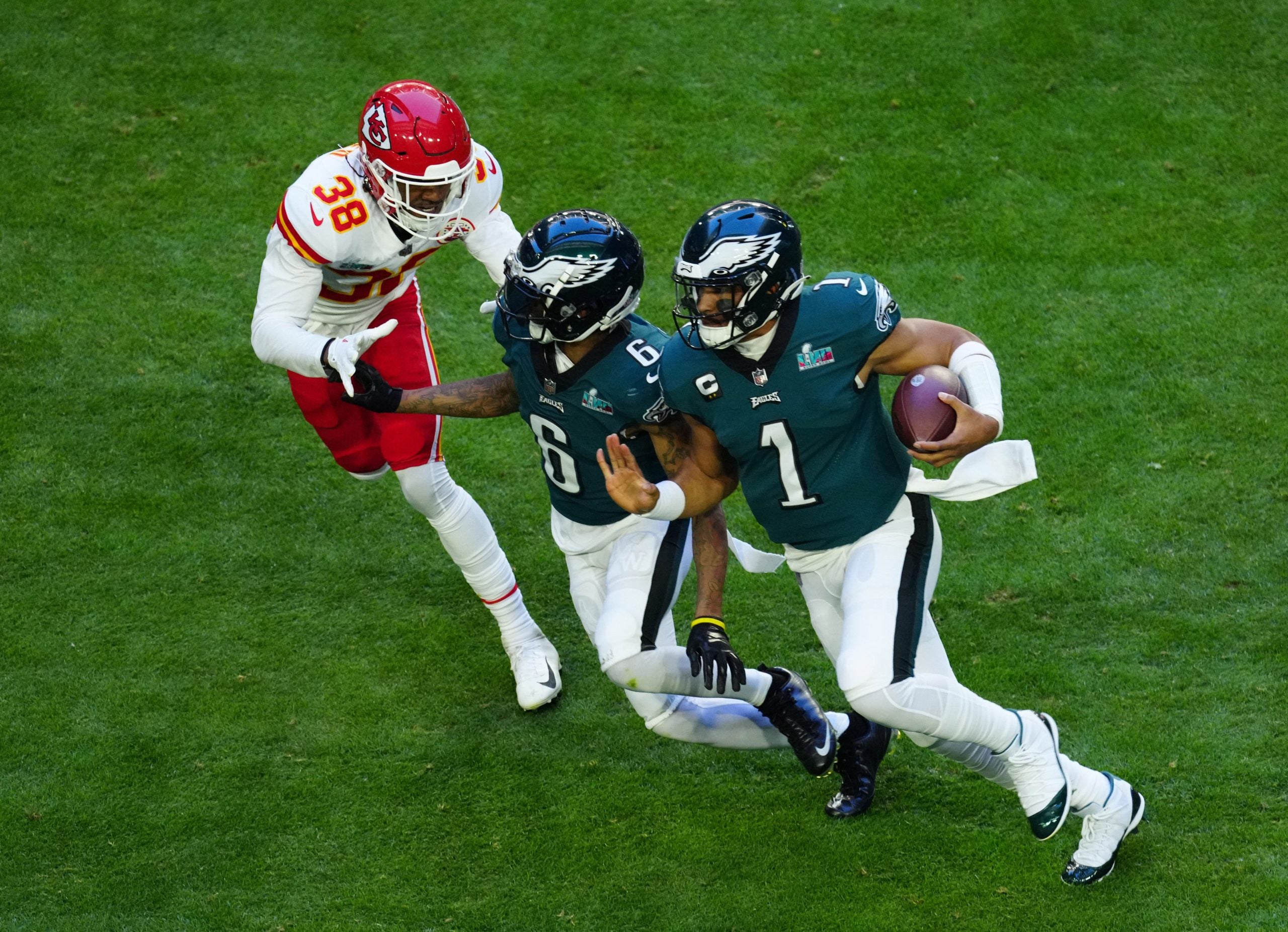 Philadelphia Eagles quarterback Jalen Hurts (1) runs the ball as wide receiver DeVonta Smith (6) blocks Kansas City Chiefs cornerback L'Jarius Sneed (38) in the first quarter in Super Bowl LVII at State Farm Stadium in Glendale on Feb. 12, 2023