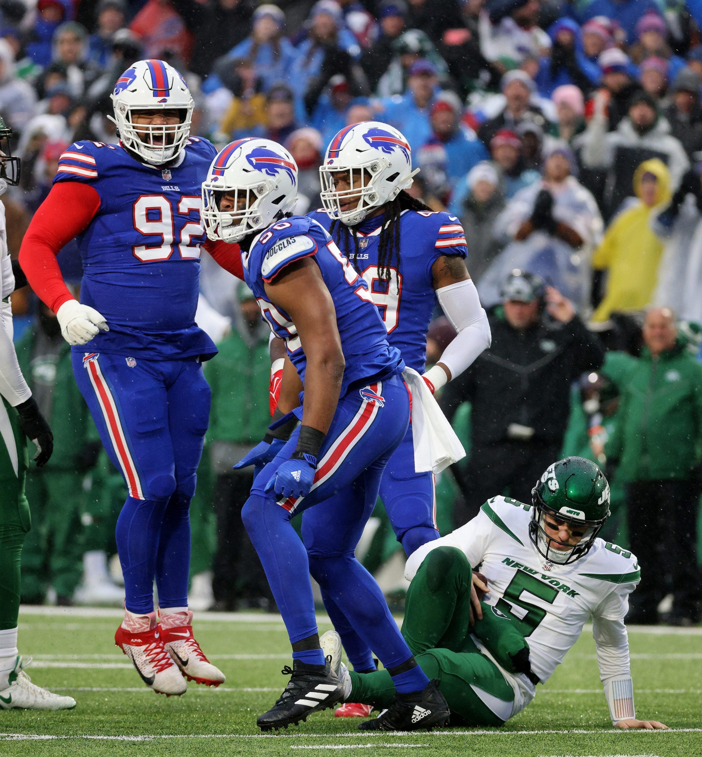 Bills Greg Rousseau celebrates a sack of Jets quarterback Mike White with teammates DaQuan Jones (92) and Tremaine Edmunds.