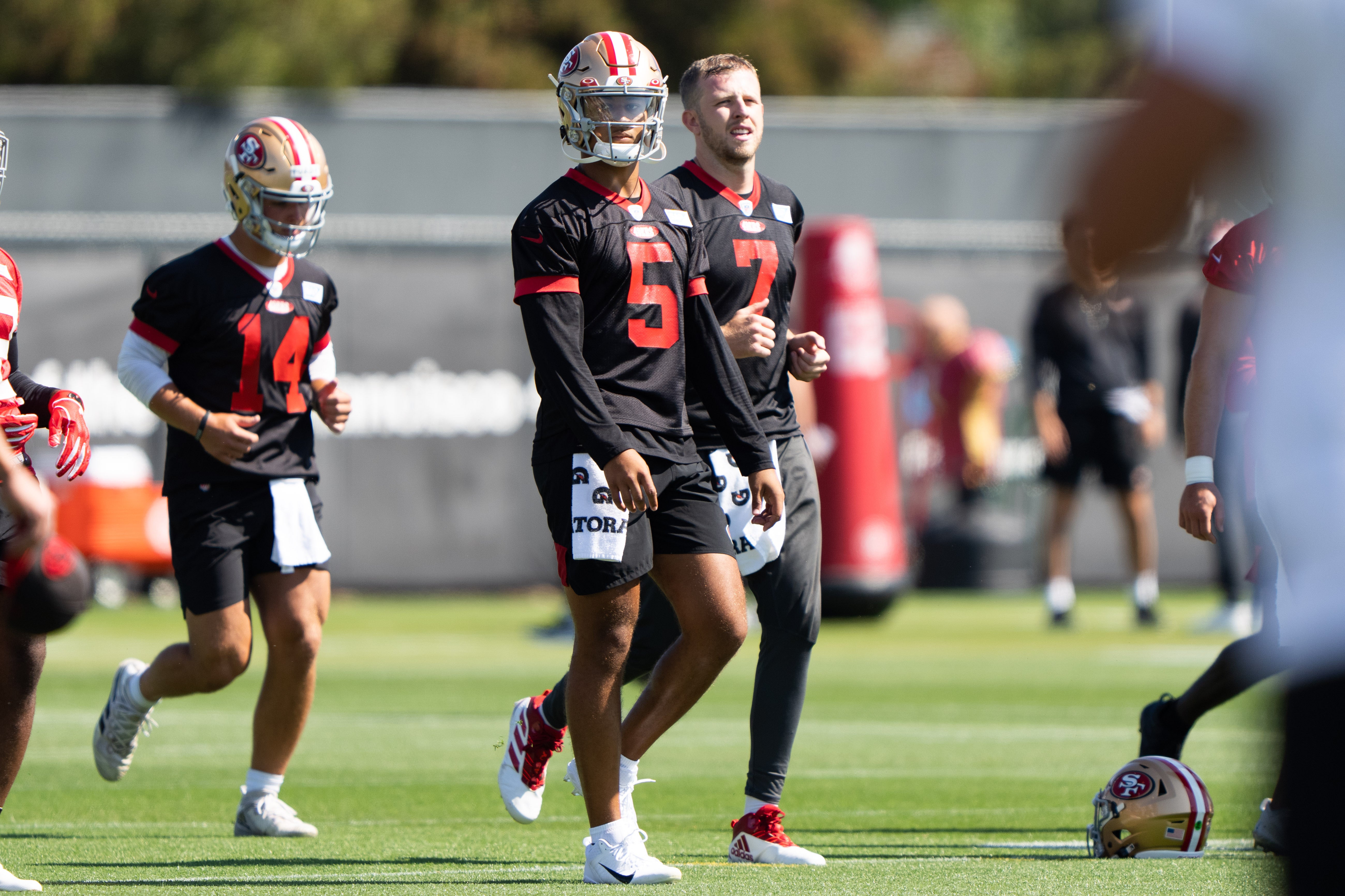ul 27, 2022; Santa Clara, CA, USA; San Francisco 49ers quarterback Trey Lance (5) walks with quarterback Nate Sudfeld (7) and quarterback Brock Purdy (14) during warm ups at the SAP Performance Facility near Levi Stadium.