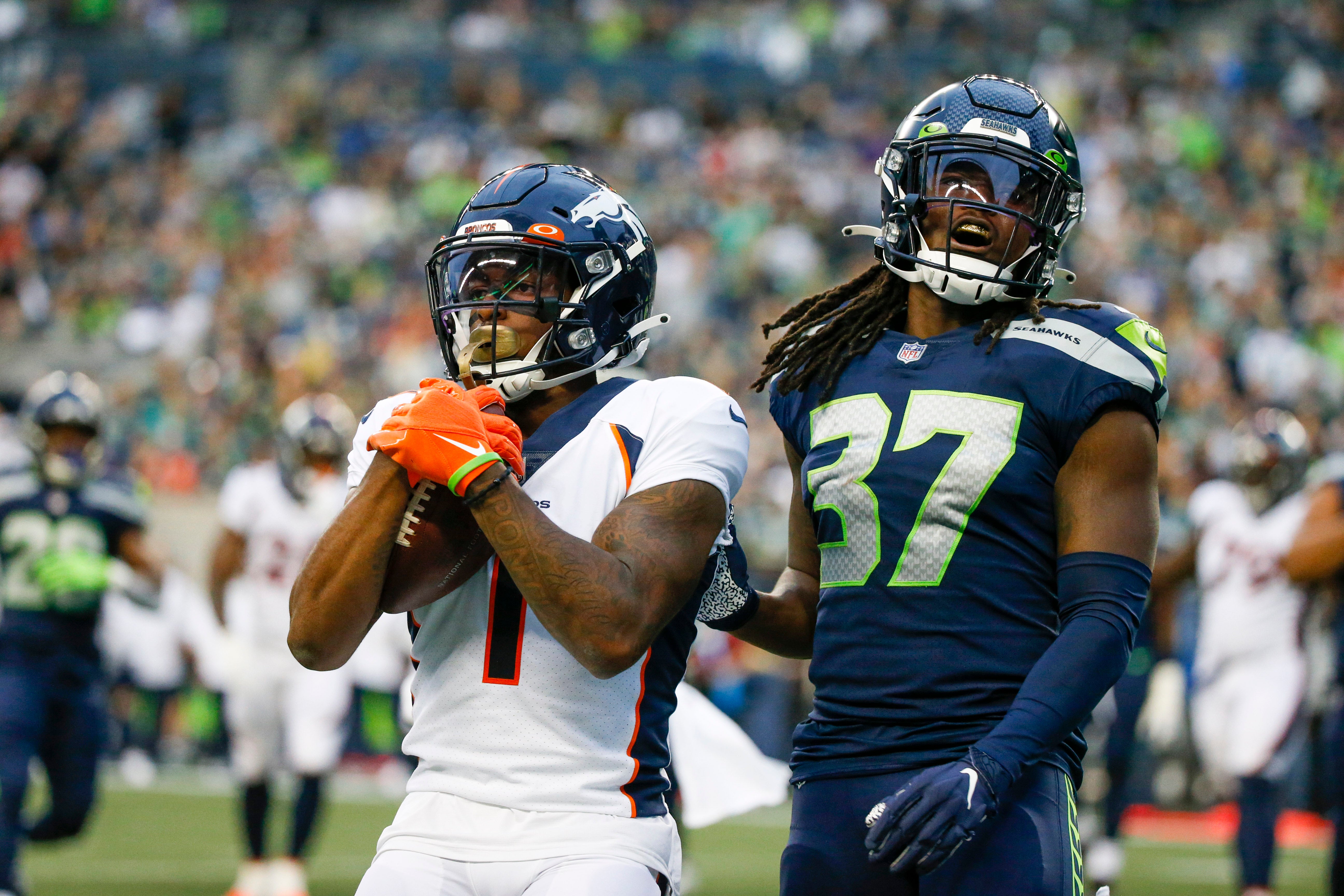 Aug 21, 2021; Seattle, Washington, USA; Denver Broncos wide receiver K.J. Hamler (1) celebrates after catching a touchdown pass in front of Seattle Seahawks safety Joshua Moon (37) during the first quarter at Lumen Field.