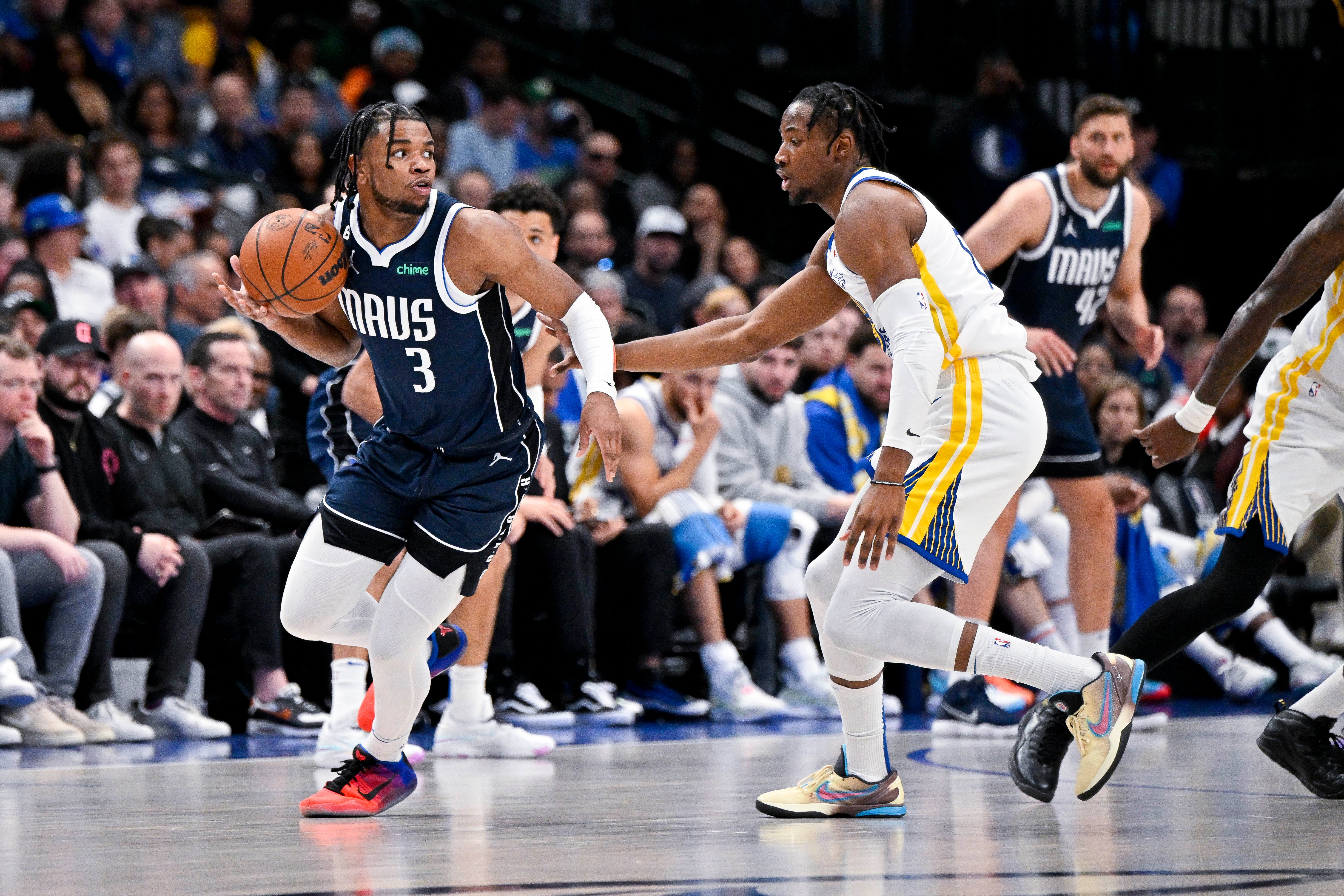 Mar 22, 2023; Dallas, Texas, USA; Dallas Mavericks guard Jaden Hardy (3) looks to passes the ball around Golden State Warriors forward Jonathan Kuminga (00) during the first quarter at the American Airlines Center.