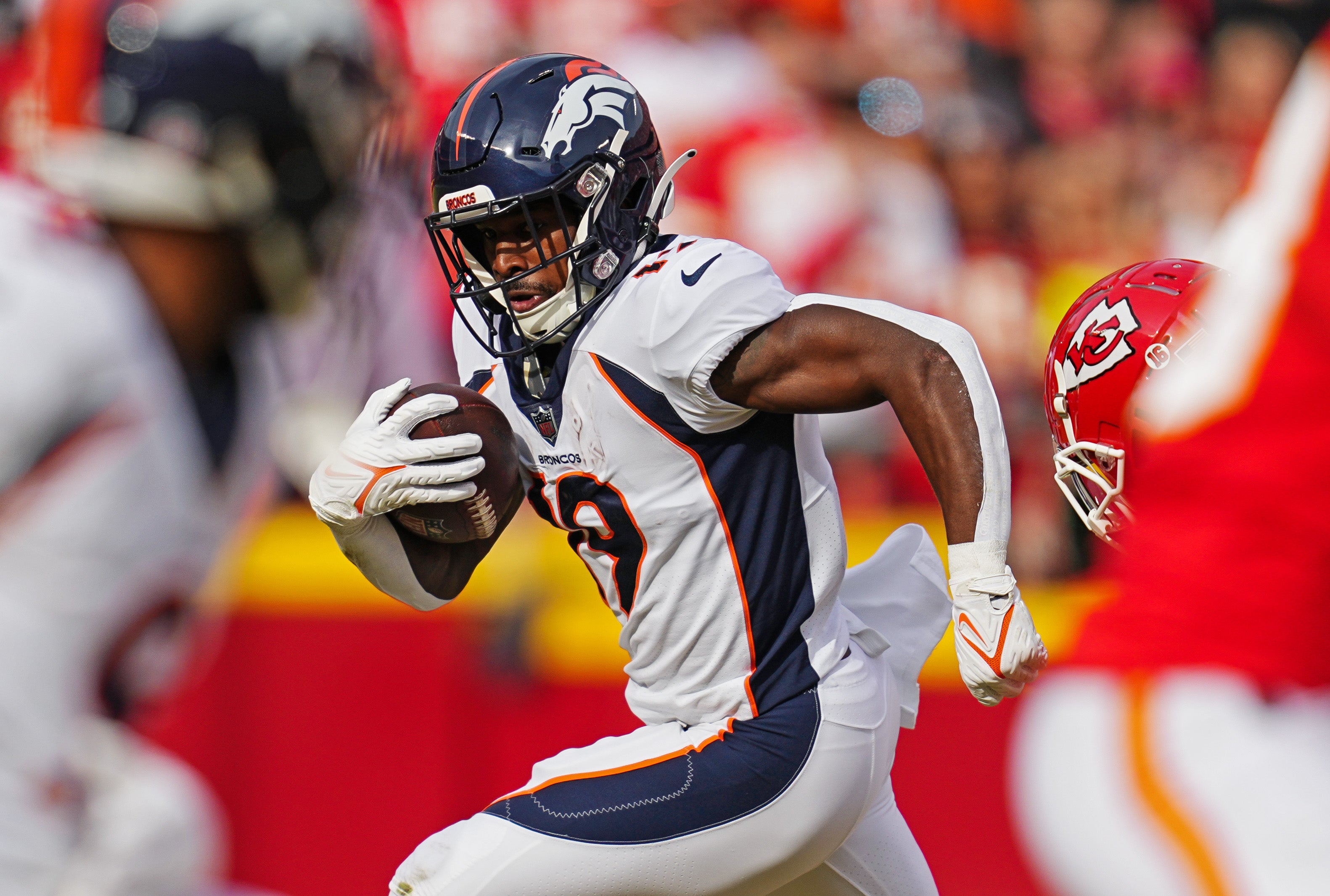 Jan 1, 2023; Kansas City, Missouri, USA; Denver Broncos running back Chase Edmonds (19) runs the ball against Kansas City Chiefs safety Justin Reid (20) during the first half at GEHA Field at Arrowhead Stadium. Mandatory Credit: Jay Biggerstaff-USA TODAY Sports