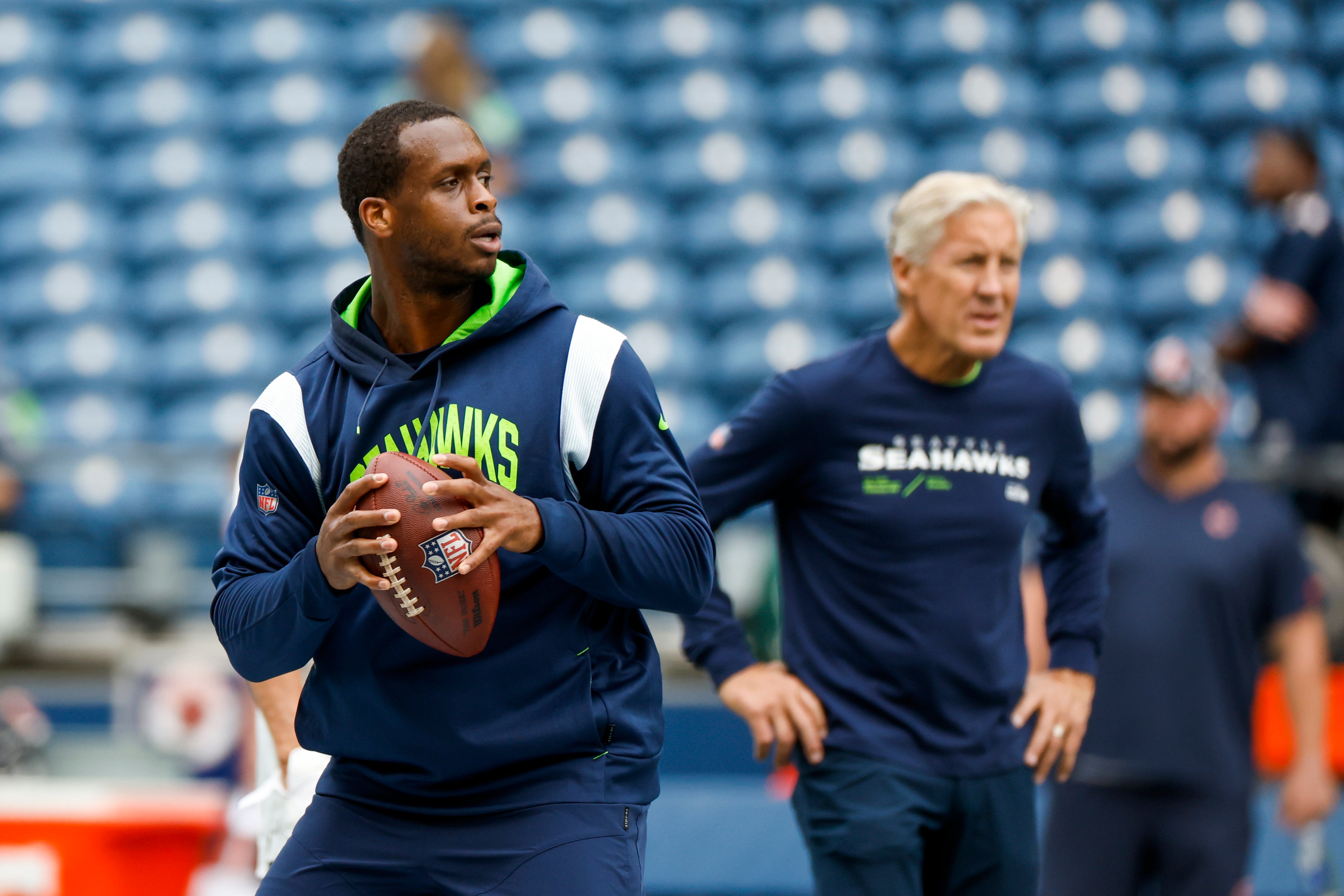 Aug 18, 2022; Seattle, Washington, USA; Seattle Seahawks quarterback Geno Smith (7) participates in early pregame warmups against the Chicago Bears while head coach Pete Carroll (background) watches at Lumen Field.