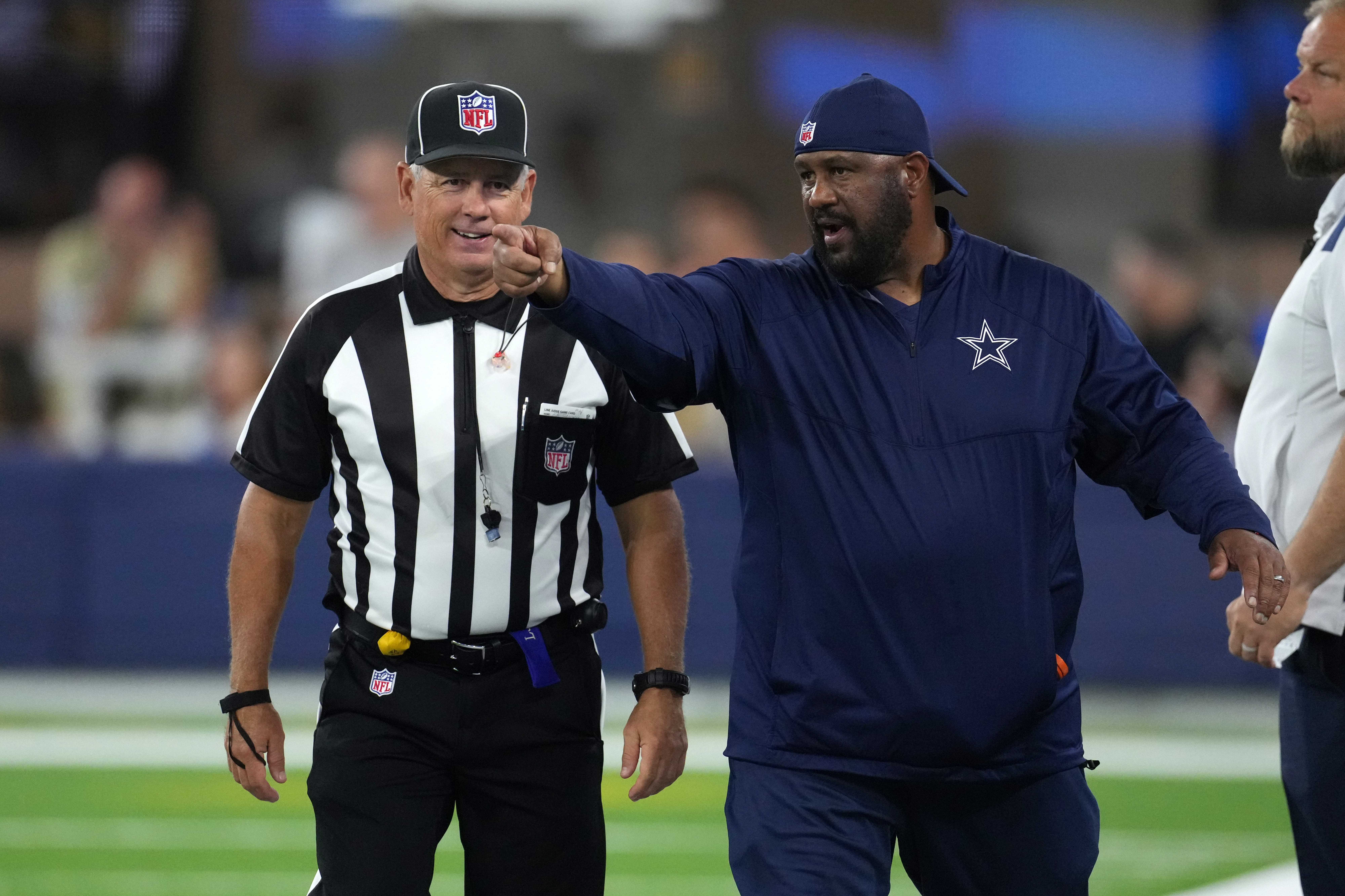 Aug 20, 2022; Inglewood, California, USA; Dallas Cowboys running backs coach Skip Peete (right) talks with line judge referee Jeff Seeman (45) in the second half against the Los Angeles Chargers at SoFi Stadium. Mandatory Credit: Kirby Lee-USA TODAY Sports