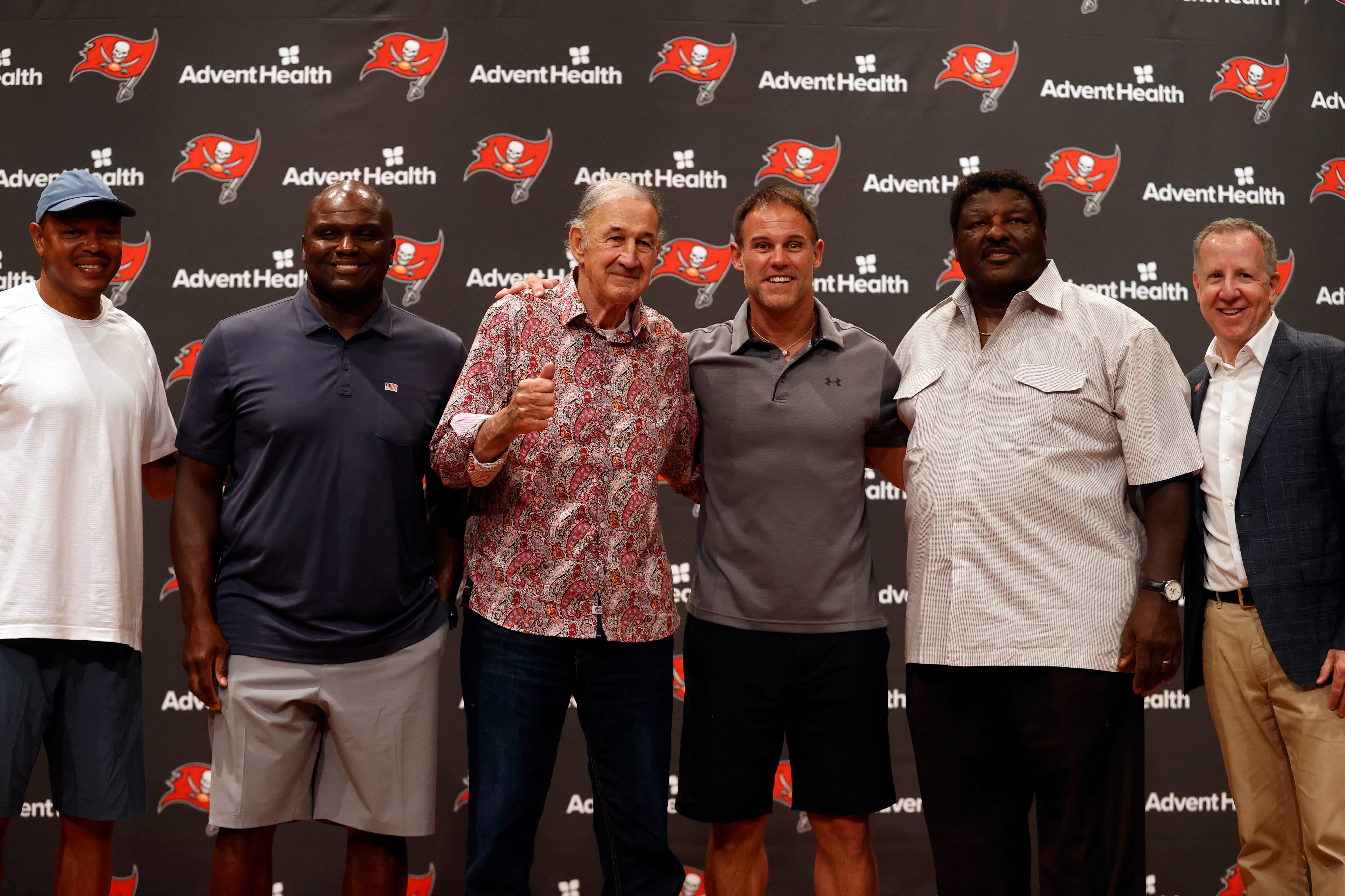 Jul 14, 2021; Tampa, Florida, USA; Tampa Bay Buccaneers former defensive coordinator Monte Kiffin gives a thumbs up as he poses for a photo with former players Sheldon Quarles and Anthony McFarland and Mike Alstott and Jimmy Giles and Buccaneers owner/co-chairman Bryan Glazer (far right) during a press conference at AdventHealth Training Center to announce that Kiffin will be entered into the Tampa Bay Buccaneers Ring of Honor. Mandatory Credit: Kim Klement-USA TODAY Sports