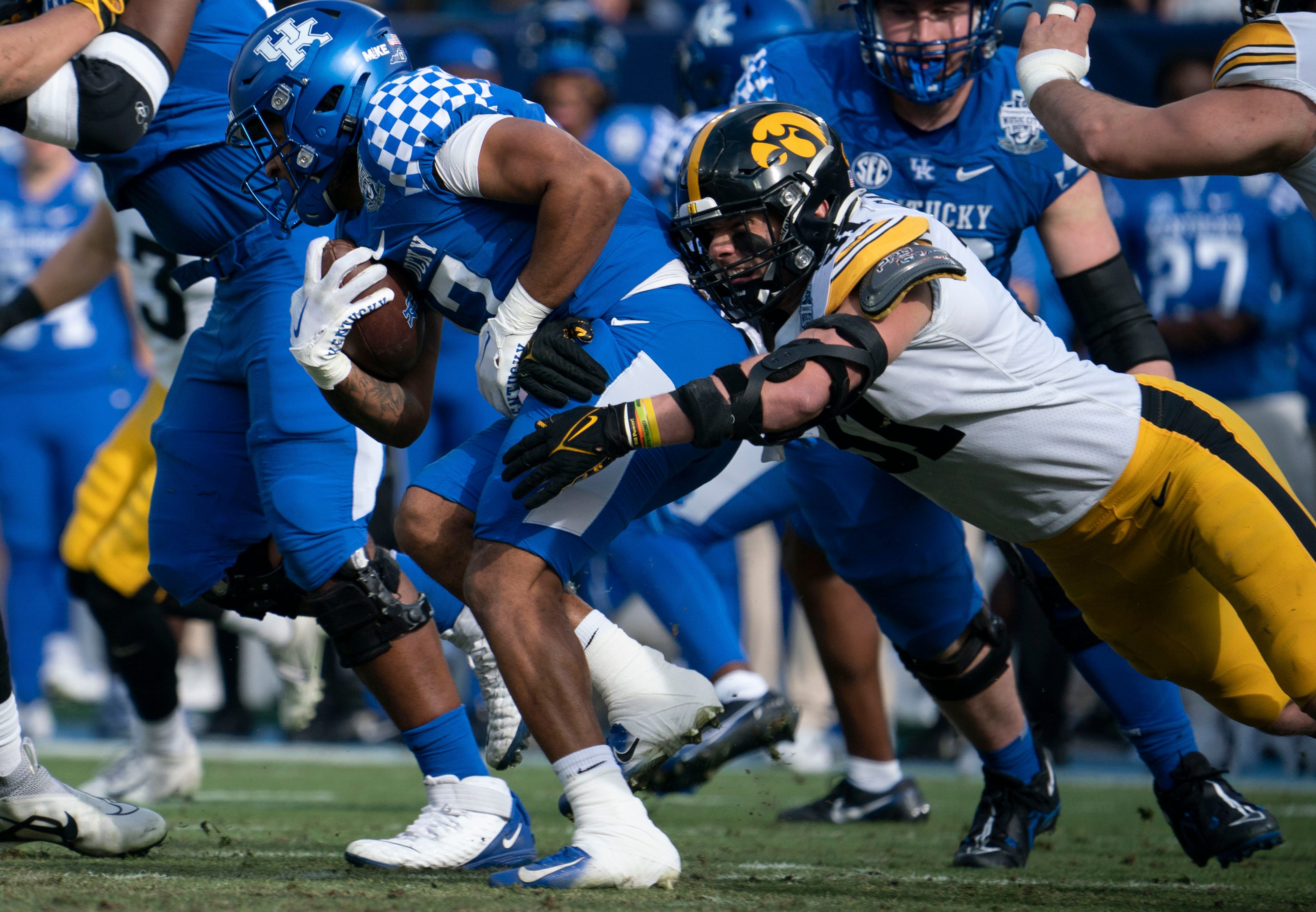 Kentucky running back JuTahn McClain (17) is stopped by Iowa linebacker Jack Campbell (31) during the first quarter of the TransPerfect Music City Bowl, Saturday, Dec. 31, 2022, at Nissan Stadium in Nashville, Tenn. Syndication The Tennessean