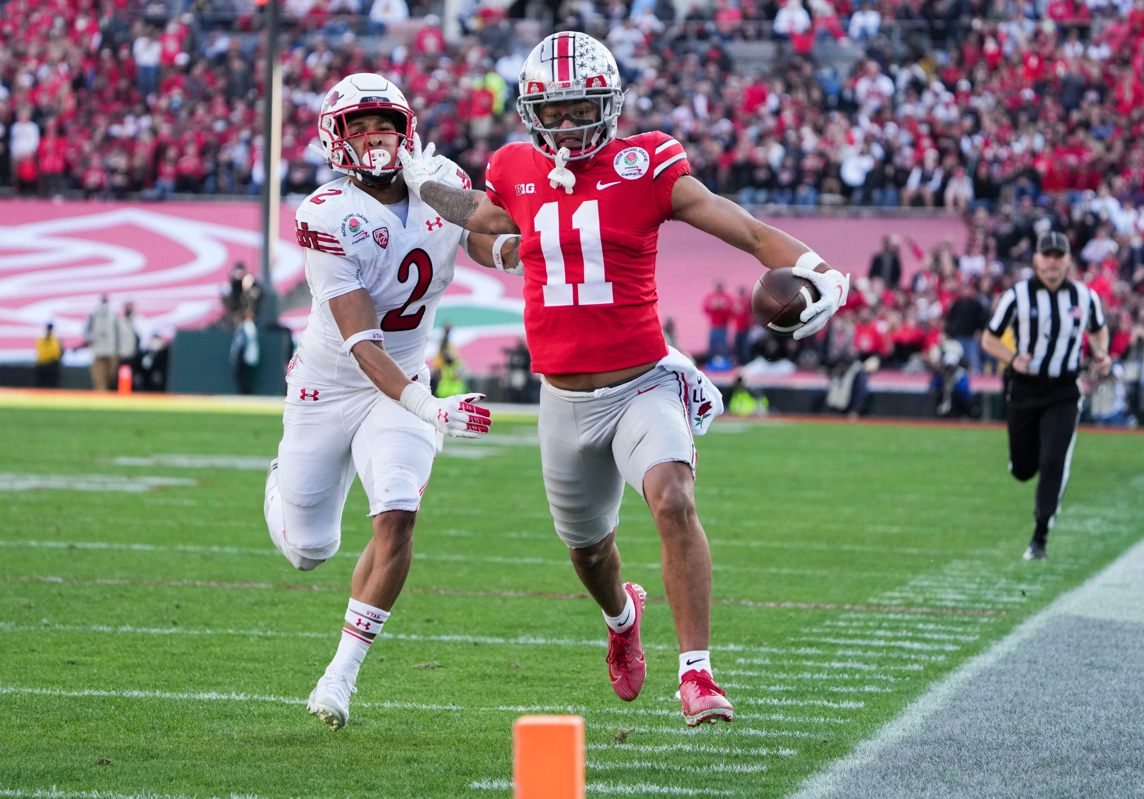 Ohio State wide receiver Jaxon Smith-Njigba fends off Utah cornerback Micah Bernard as he races to the end zone for a touchdown during the second quarter of the 2022 Rose Bowl in Pasadena, Calif.