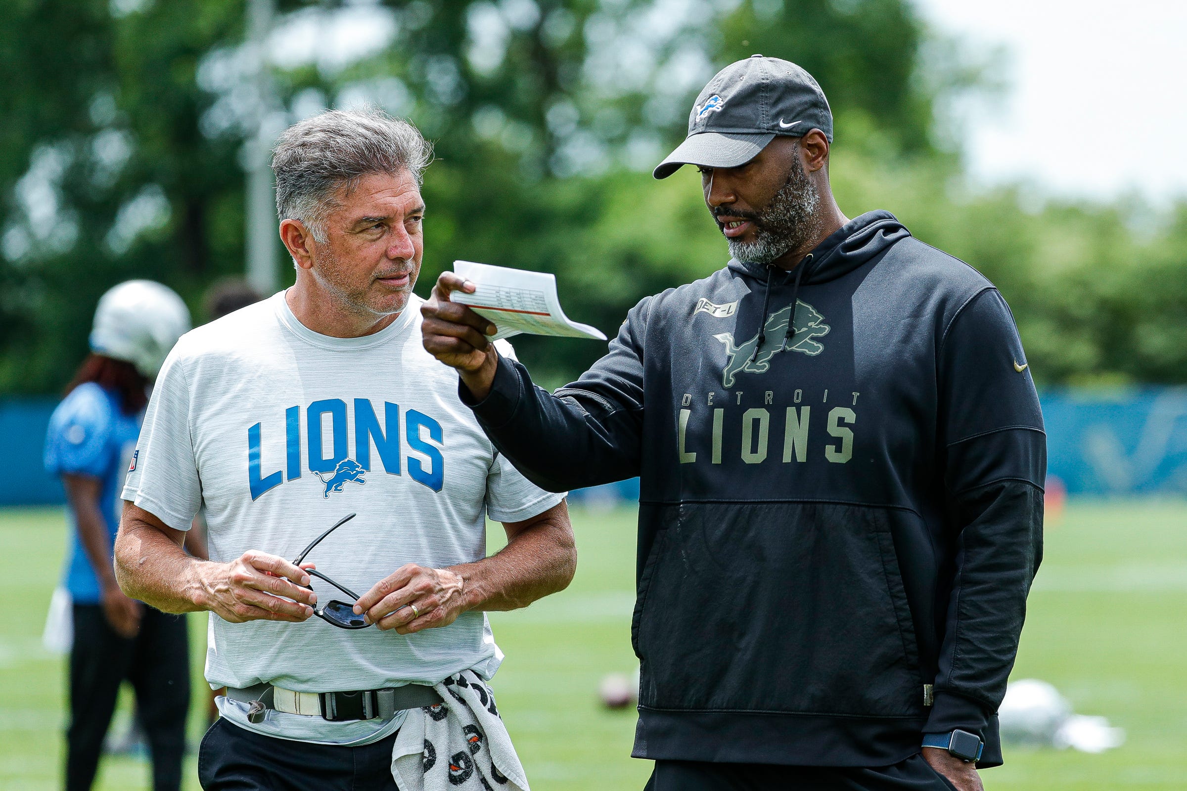 Lions head athletic trainer Kevin Bastin, left, talks to general manager Brad Holme during minicamp in Allen Park on Wednesday, June 8, 2022.