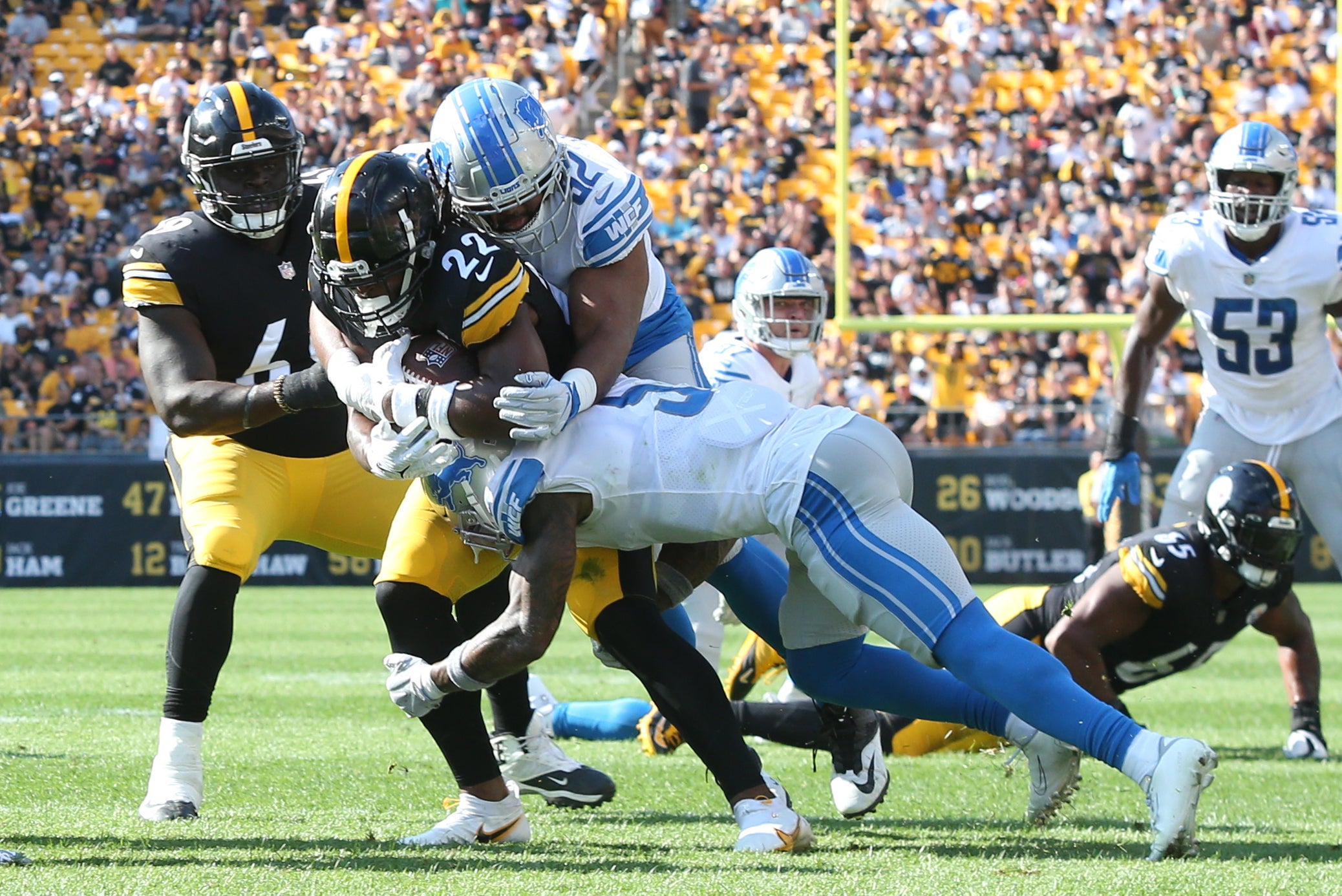 Aug 28, 2022; Pittsburgh, Pennsylvania, USA; Pittsburgh Steelers running back Najee Harris (22) carries the ball as Detroit Lions defensive end Demetrius Taylor (62) and safety DeShon Elliott (5) defend during the first quarter at Acrisure Stadium. Mandatory Credit: Charles LeClaire-USA TODAY Sports