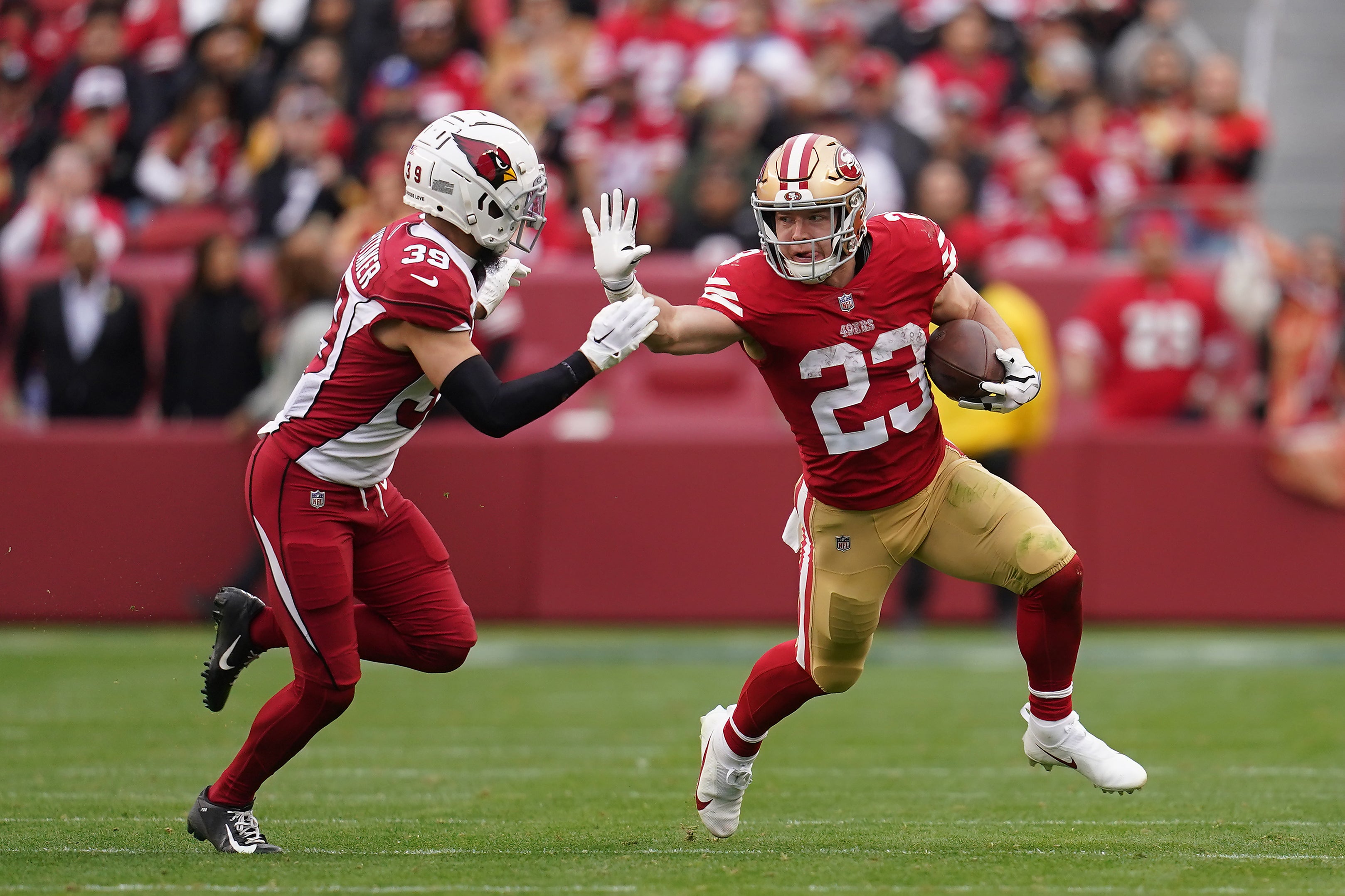 Jan 8, 2023; Santa Clara, California, USA; San Francisco 49ers running back Christian McCaffrey (23) stiff arms Arizona Cardinals cornerback Jace Whittaker (39) in the third quarter at Levi's Stadium