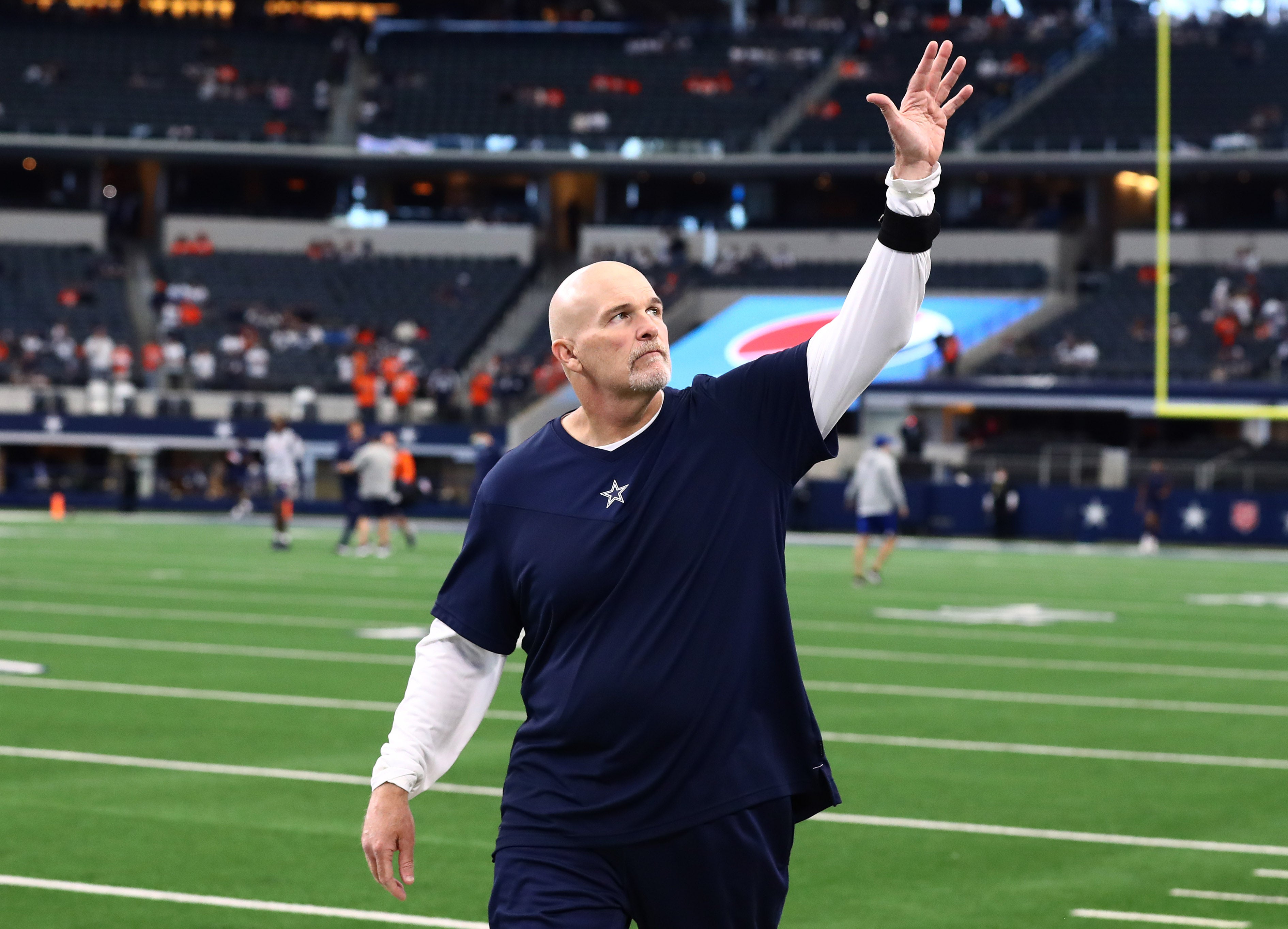 Dallas Cowboys defensive coordinator Dan Quinn waving to the crowd at AT&T Stadium