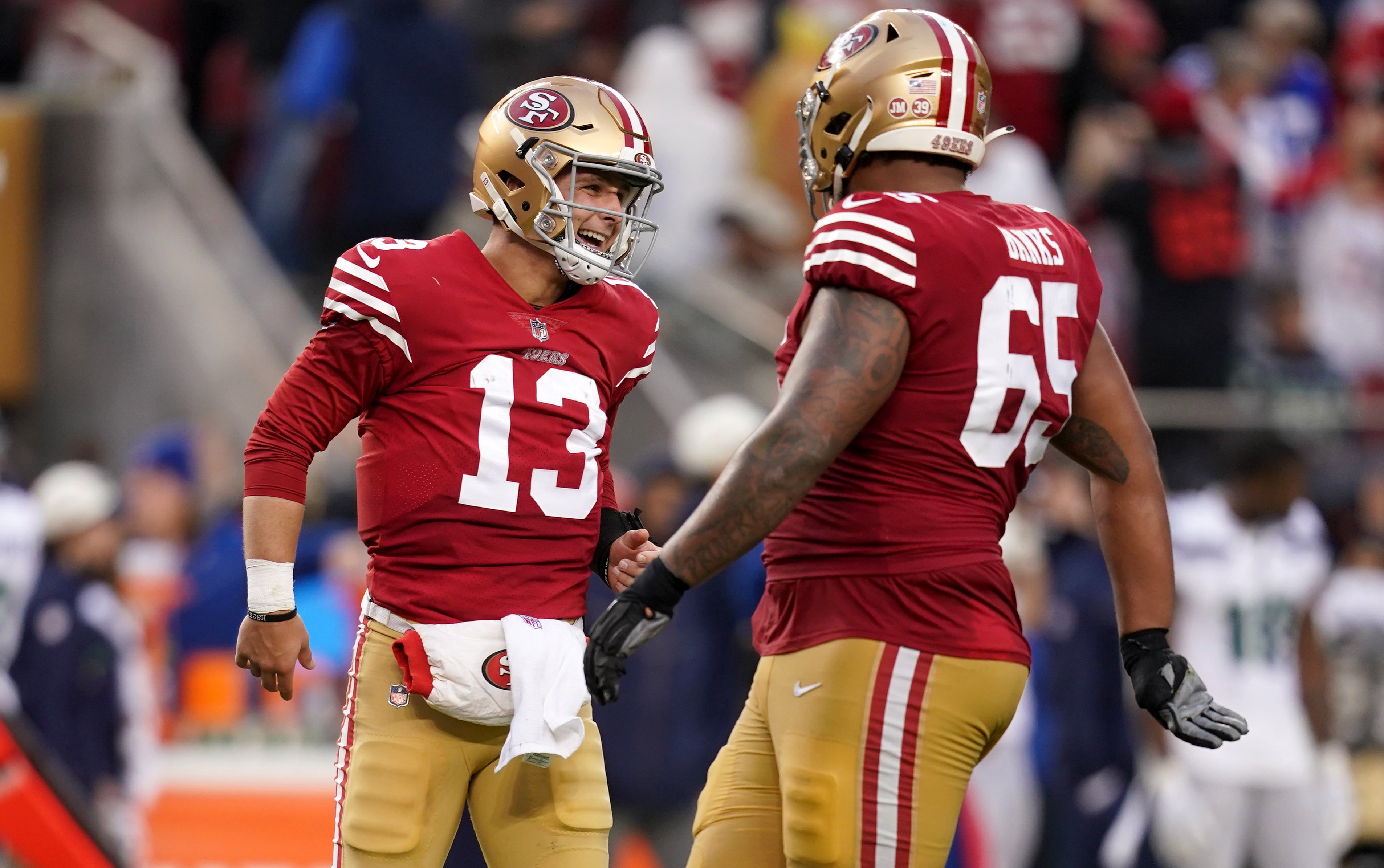Jan 14, 2023; Santa Clara, California, USA; San Francisco 49ers quarterback Brock Purdy (13) talks to guard Aaron Banks (65) in the fourth quarter of a wild card game against the Seattle Seahawks at Levi's Stadium.
