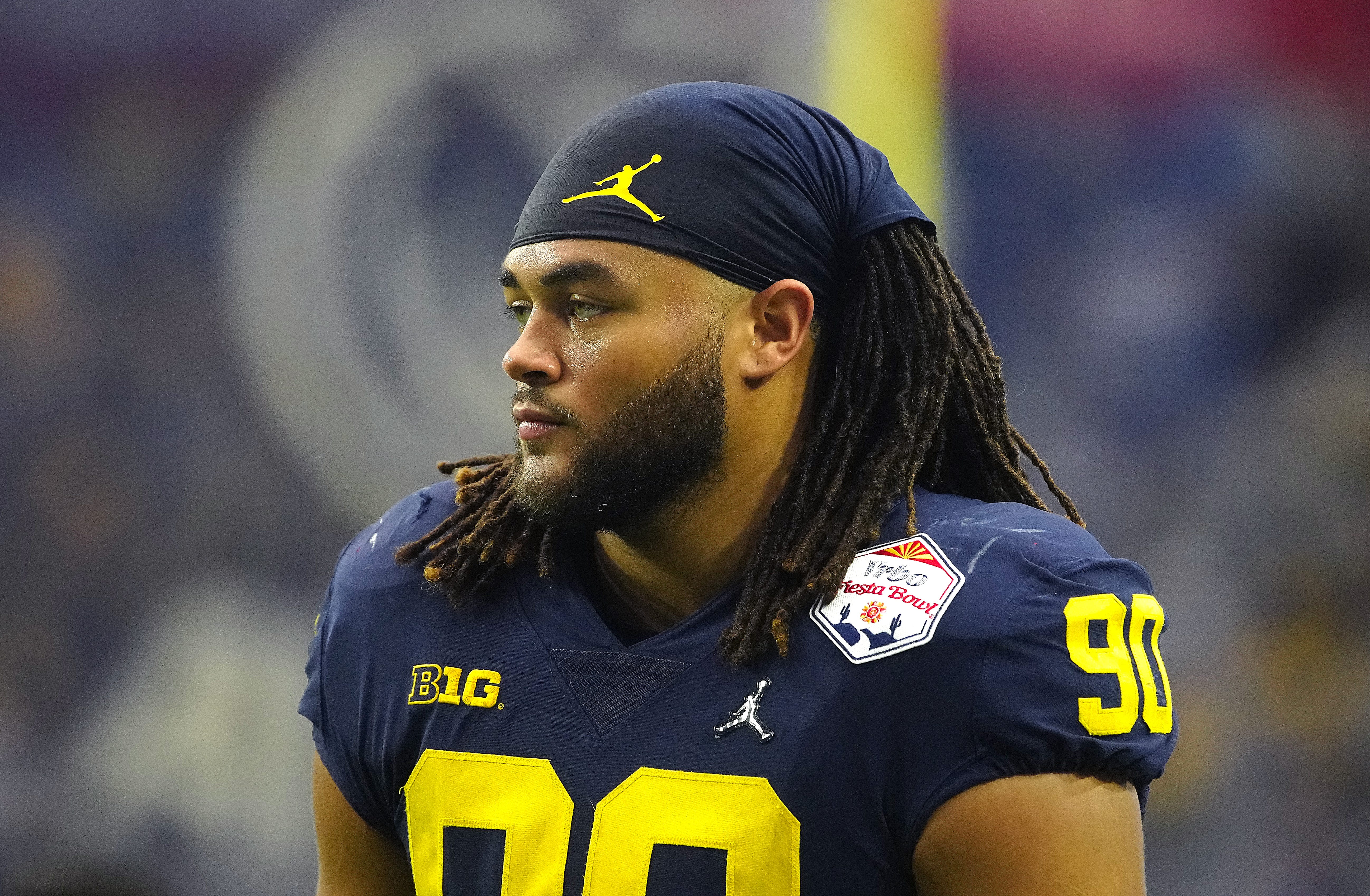 December 31, 2022; Glendale, Ariz; USA; Michigan edge rusher Mike Morris (90) looks on to the field during pregame before the Fiesta Bowl at State Farm Stadium.