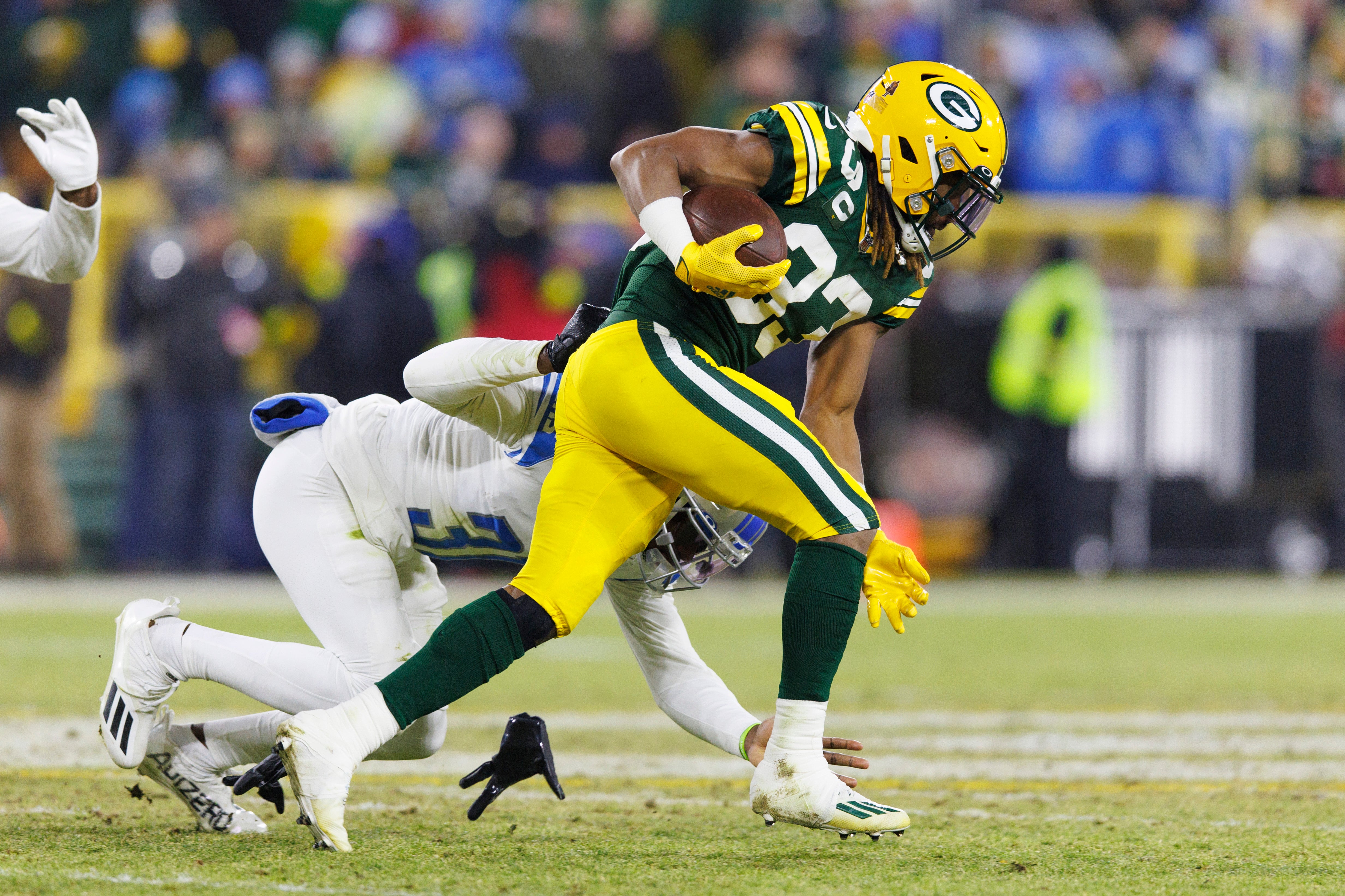 Green Bay Packers RB Aaron Jones fighting a tackle attempt from the Detroit Lions