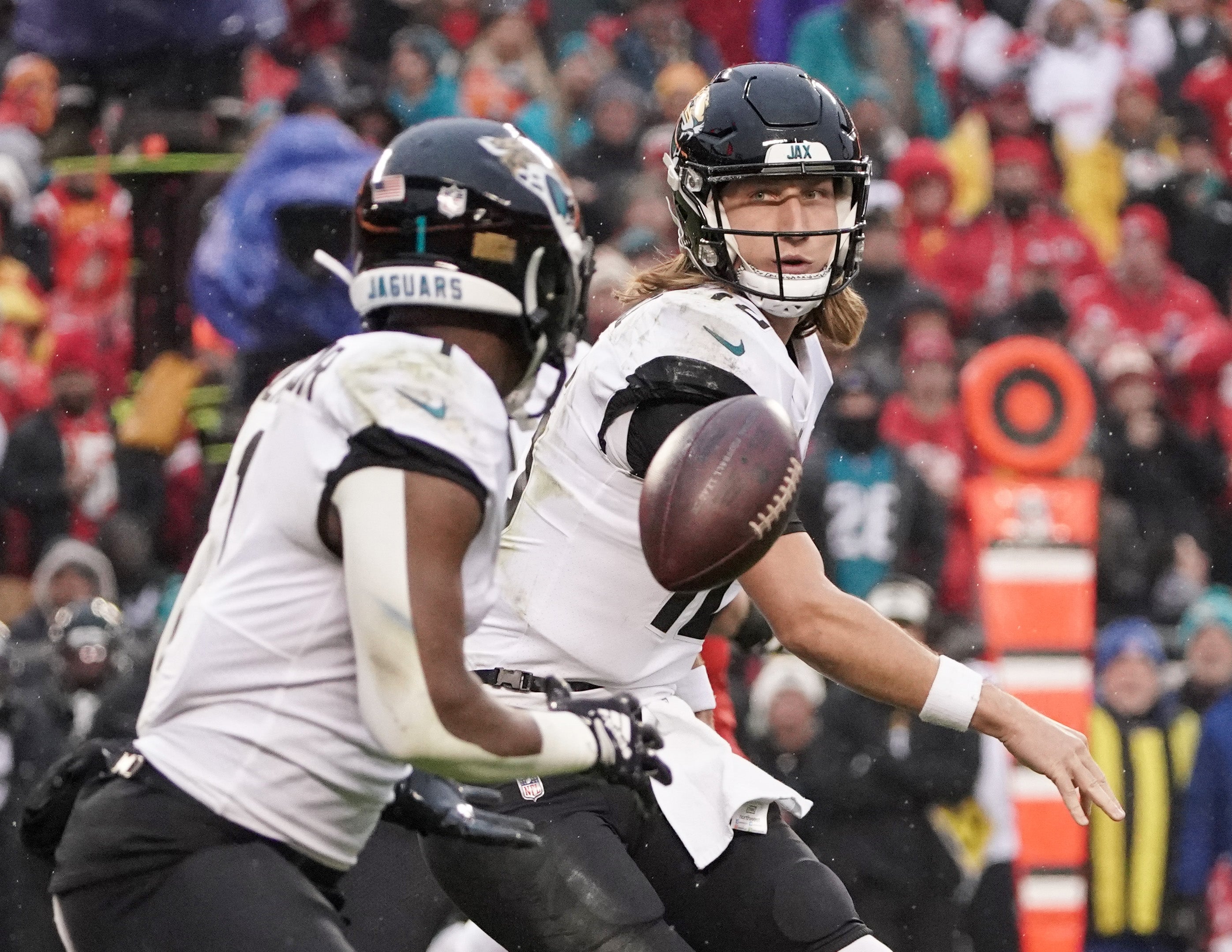Jacksonville Jaguars quarterback Trevor Lawrence tosses the ball to running back Travis Etienne Jr. at Arrowhead vs. Kansas City Chiefs.