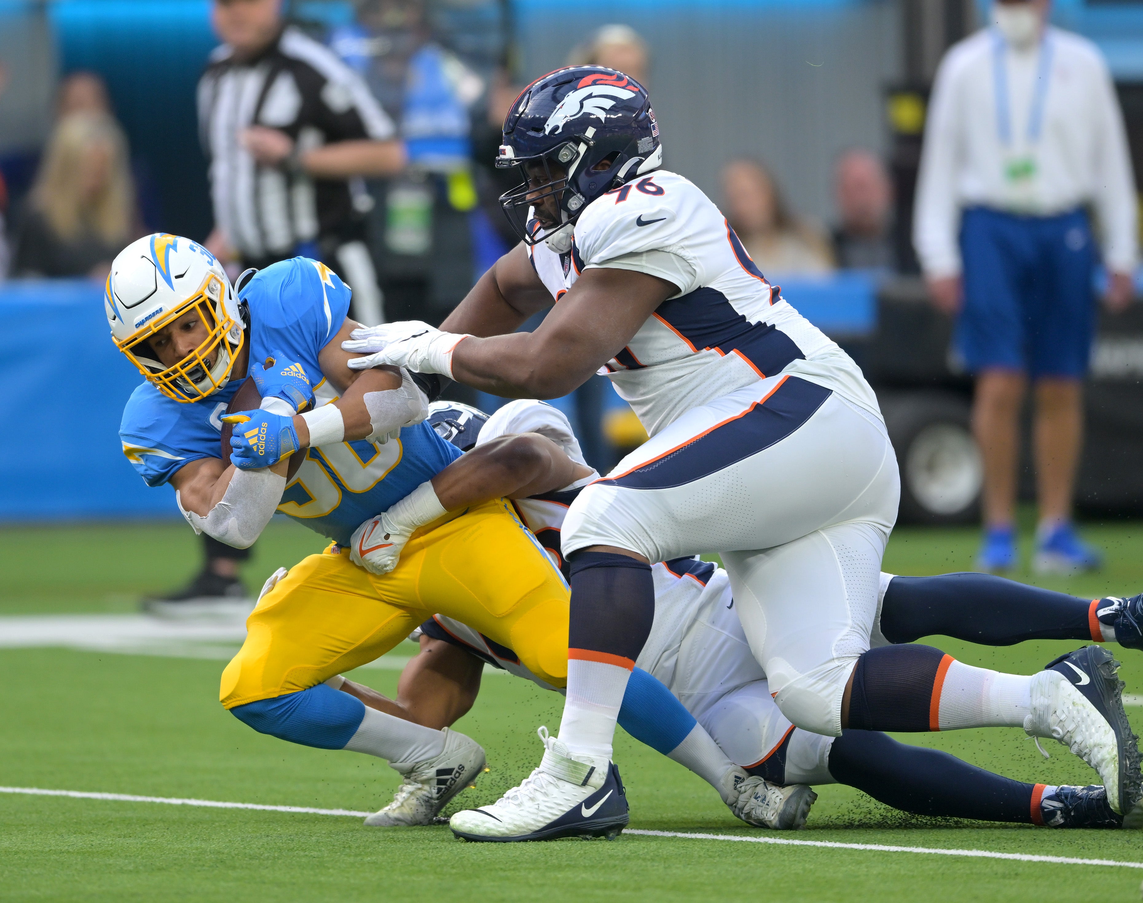 Jan 2, 2022; Inglewood, California, USA; Los Angeles Chargers running back Austin Ekeler (30) is stopped short of the goal line as he is stopped by Denver Broncos offensive tackle Calvin Anderson (76) in the first quarter of the game at SoFi Stadium.