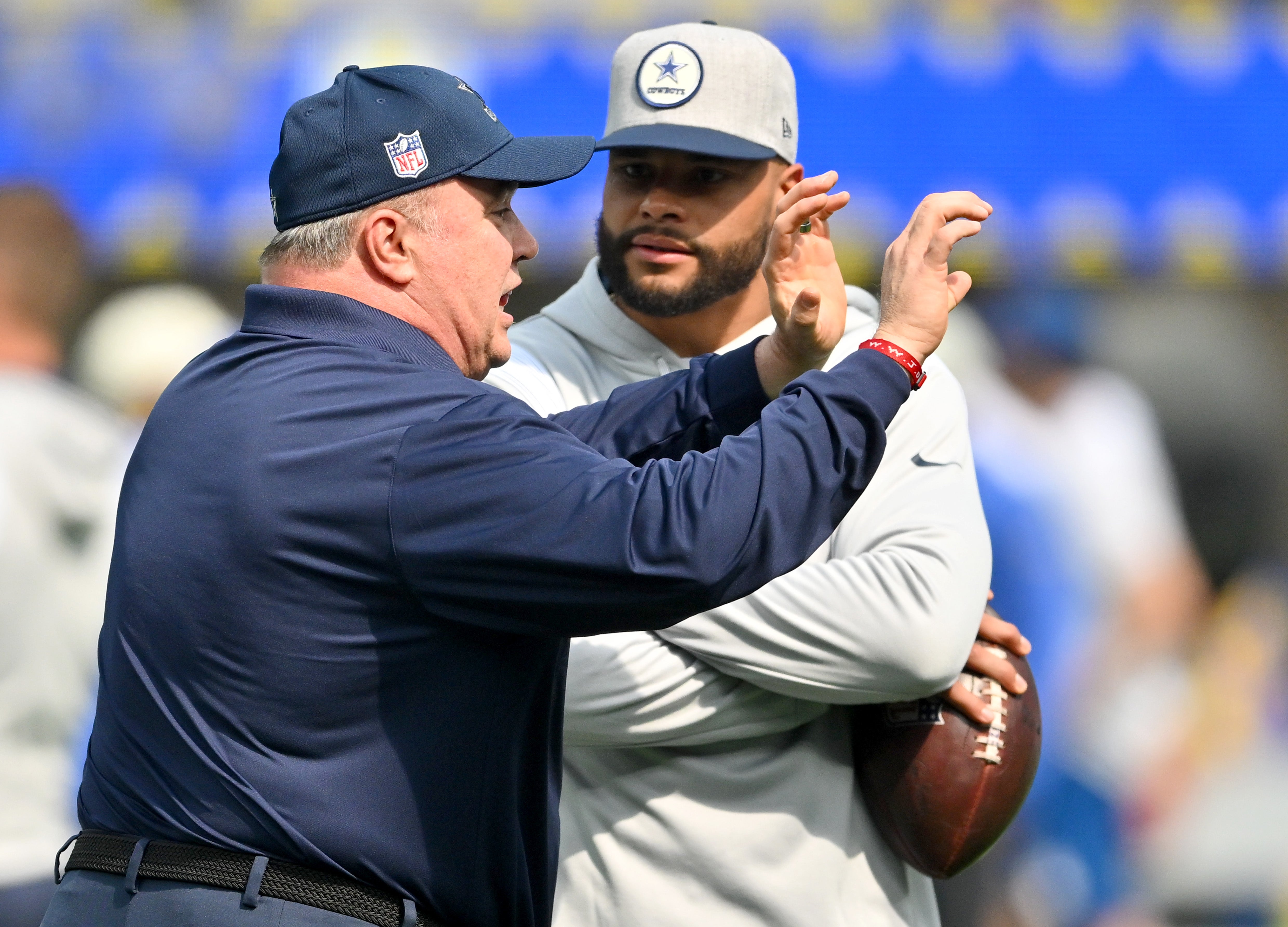 Dallas Cowboys HC Mike McCarthy hablando con su quarterback  Dak Prescott.