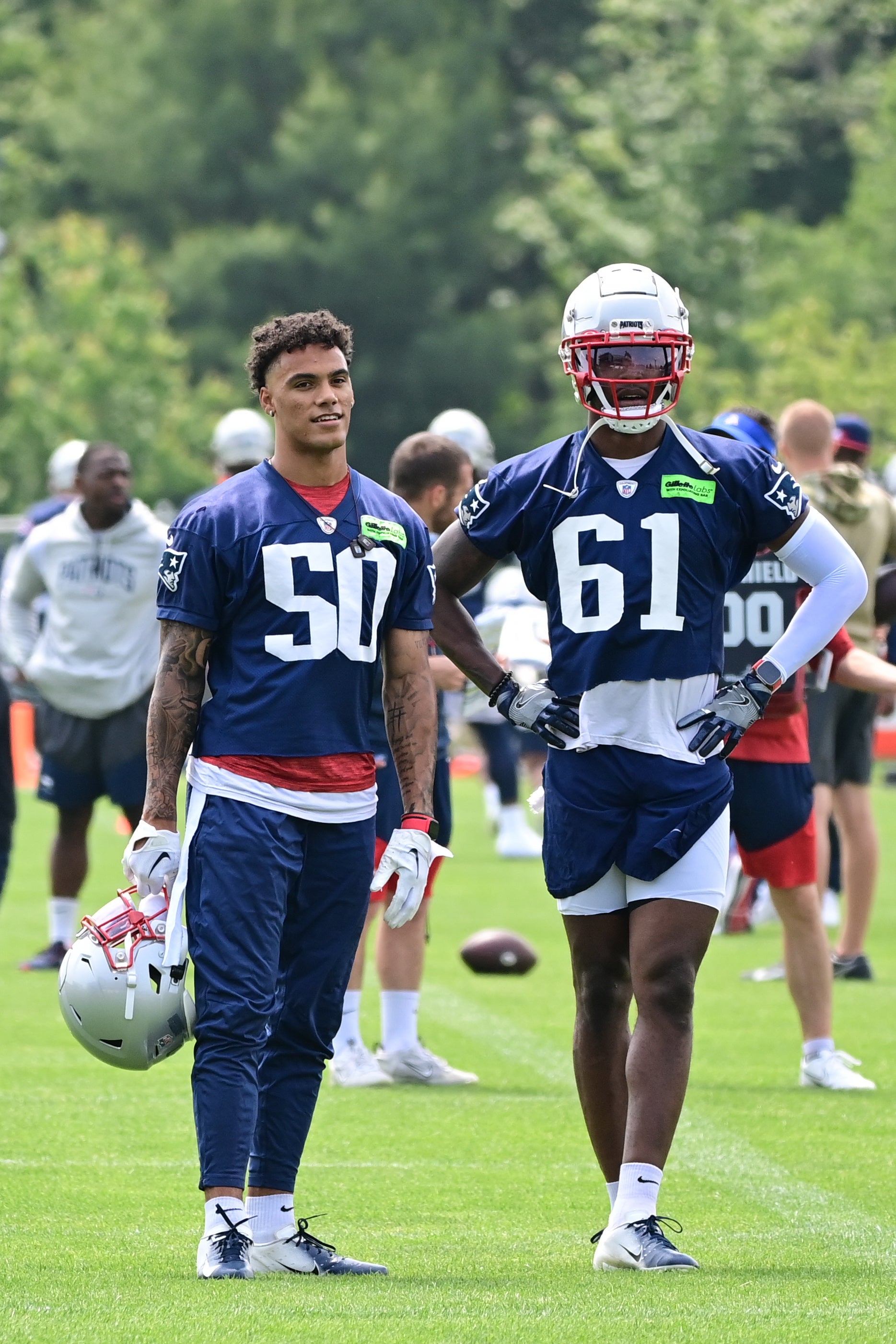 Jun 12, 2023; Foxborough, MA, USA; New England Patriots cornerback Christian Gonzalez (50) and cornerback Ameer Speed (61) watch others practice at the Patriots minicamp at Gillette Stadium.