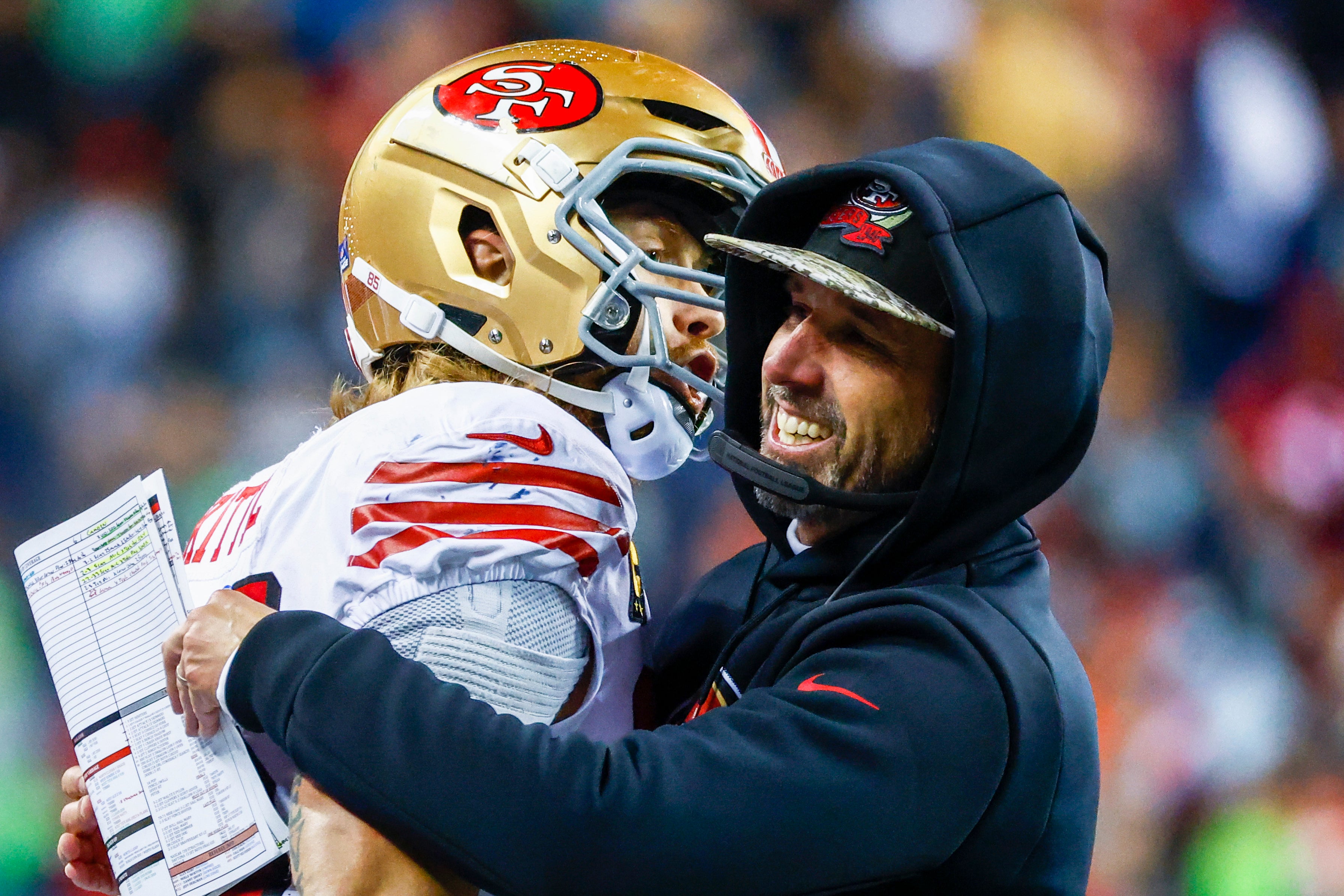 Dec 15, 2022; Seattle, Washington, USA; San Francisco 49ers head coach Kyle Shanahan, right, hugs tight end George Kittle (85) during the late fourth quarter of a 21-13 victory against the Seattle Seahawks at Lumen Field.