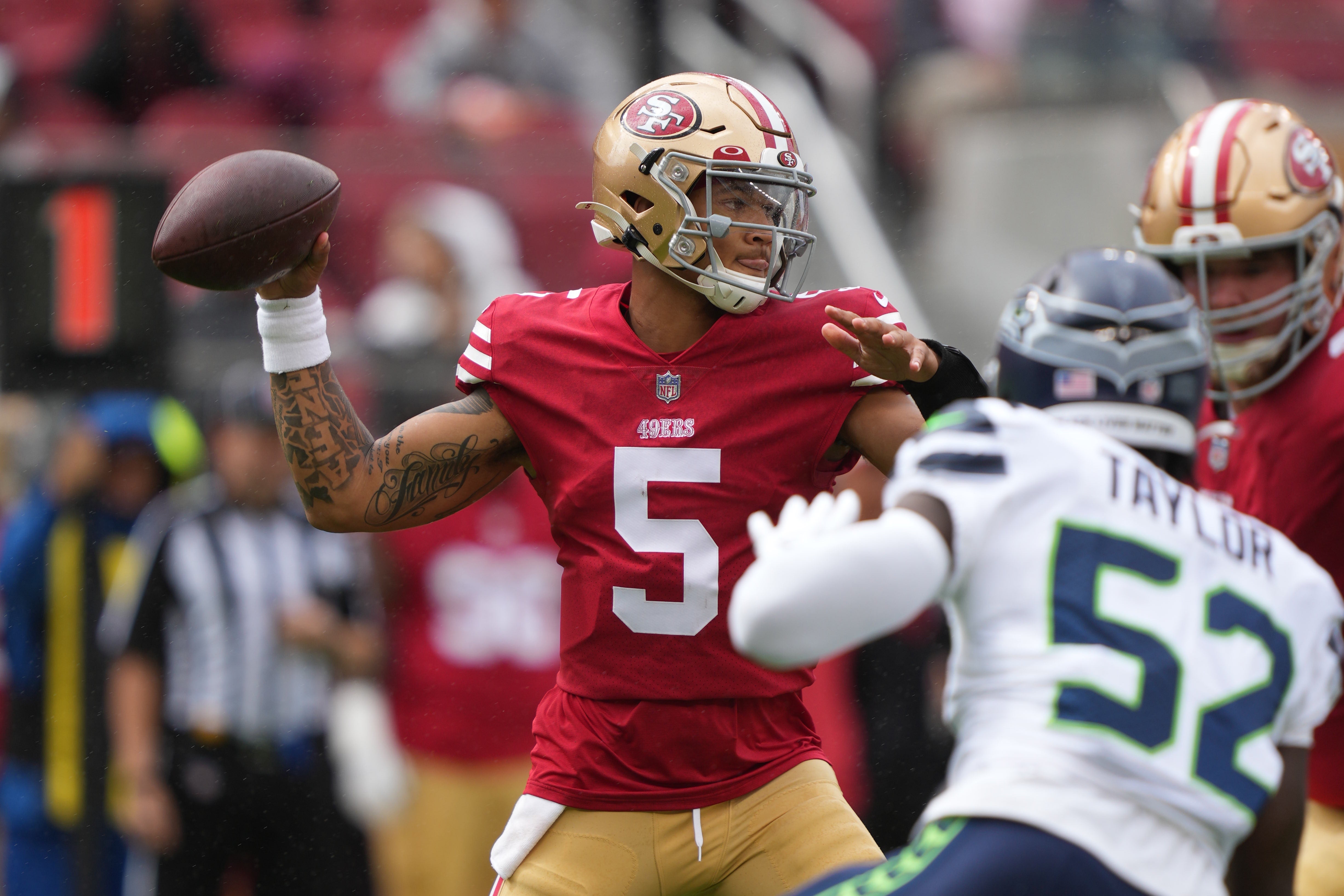 September 18, 2022; Santa Clara, California, USA; San Francisco 49ers quarterback Trey Lance (5) passes the football against Seattle Seahawks defensive end Darrell Taylor (52) during the first quarter at Levi's Stadium.
